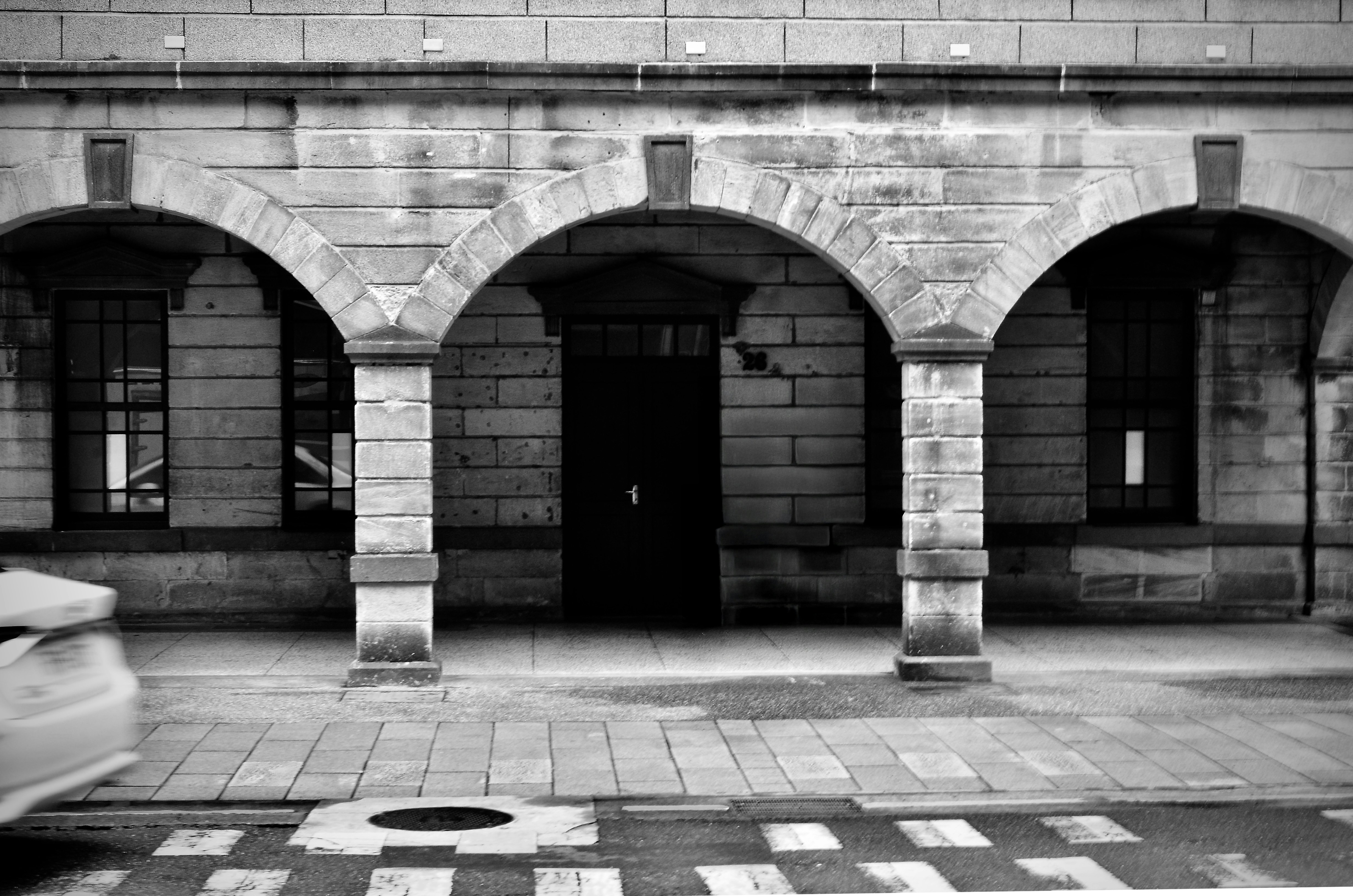 Bâtiment en pierre avec entrée en arc et fenêtres