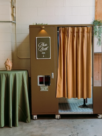 Vintage photo booth with mustard curtain at event venue