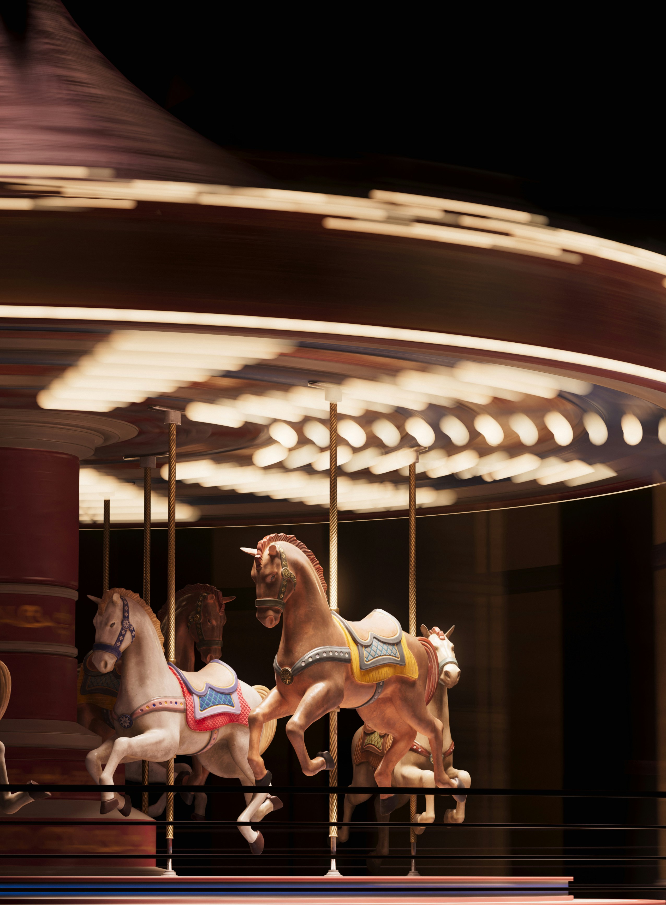 Motion-blurred carousel with horses at night.