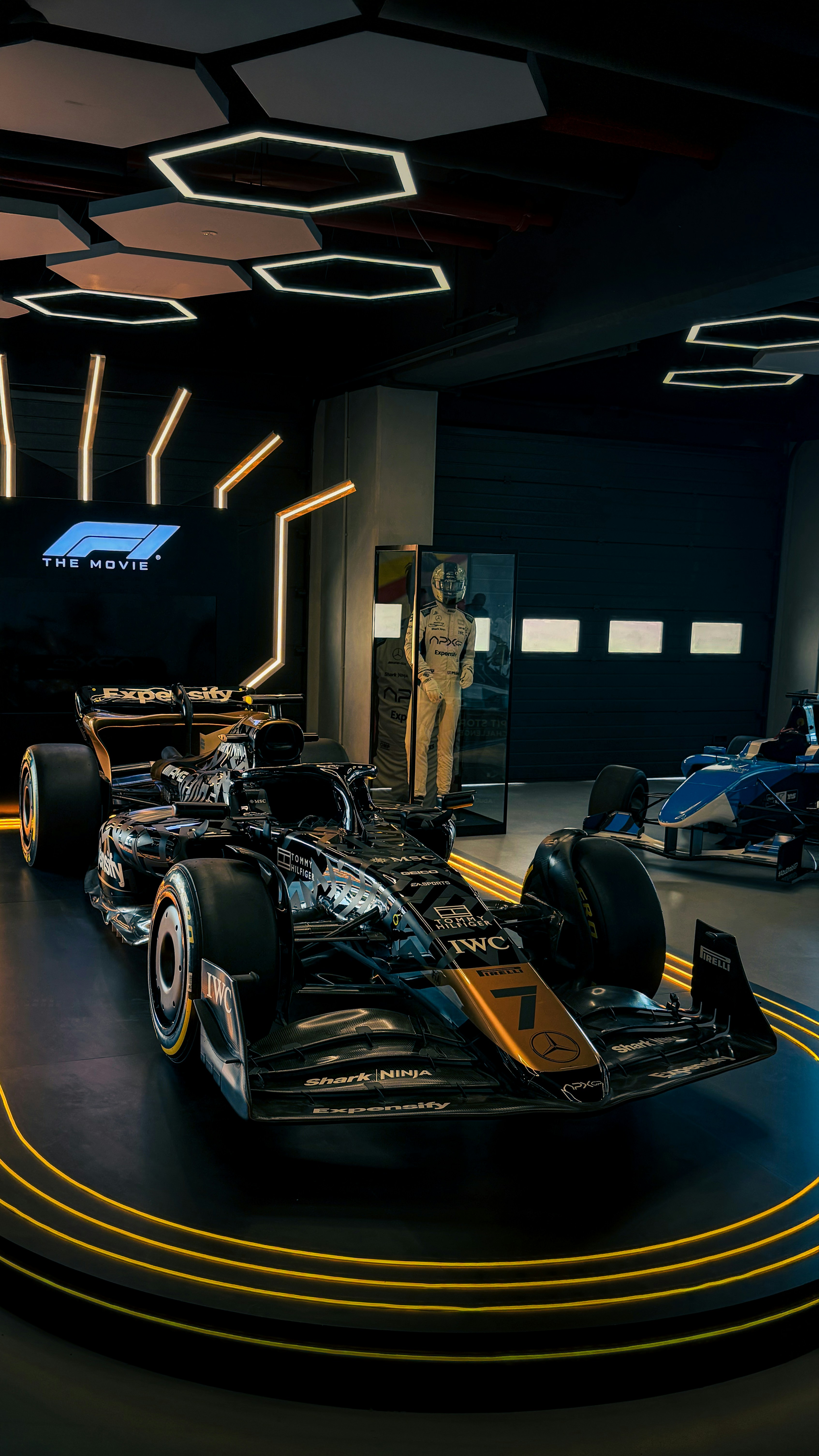 Mobil formula 1 hitam dan oranye dipamerkan.