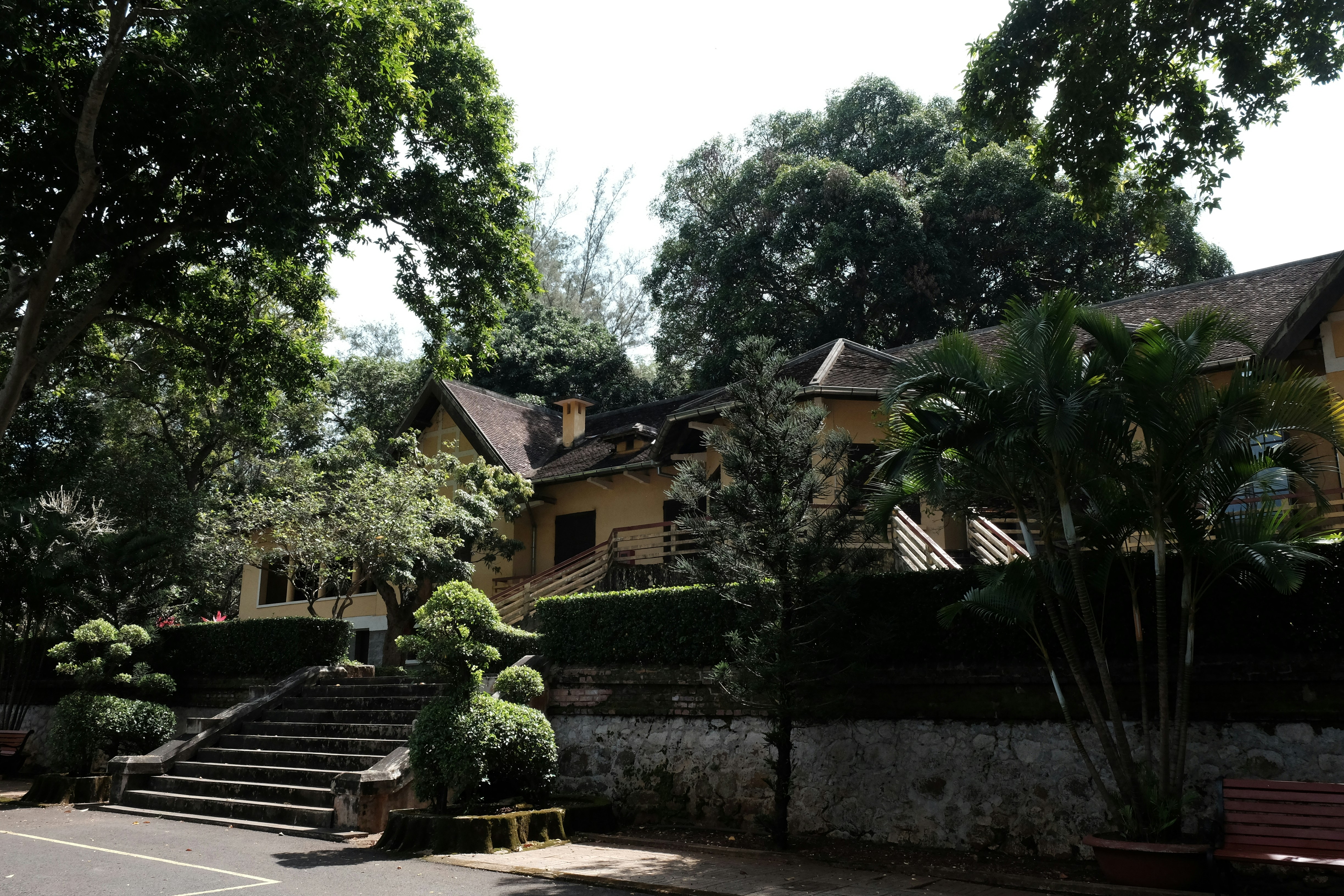 A large yellow house surrounded by lush green trees.