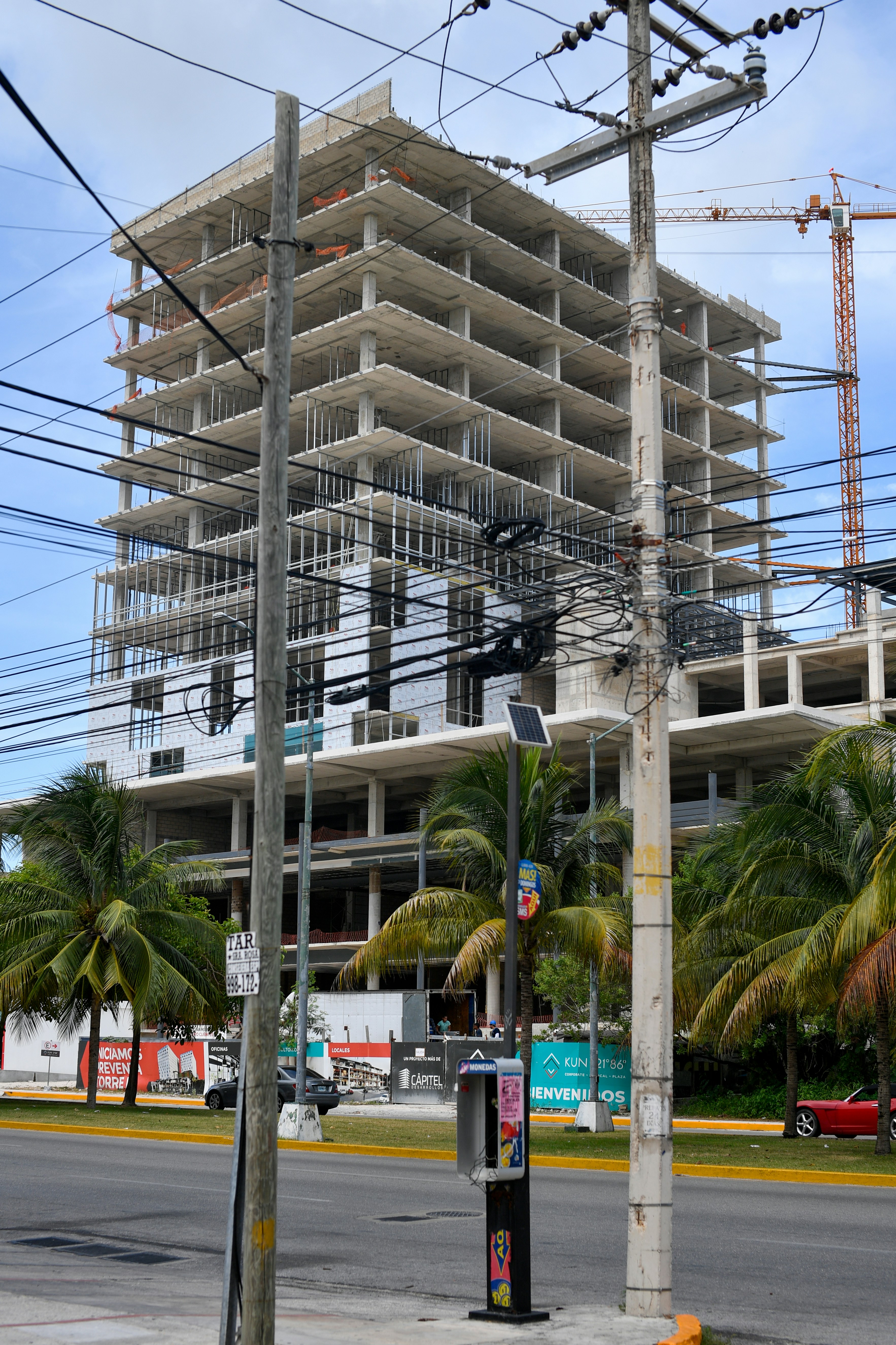 High-rise building under construction with power lines.