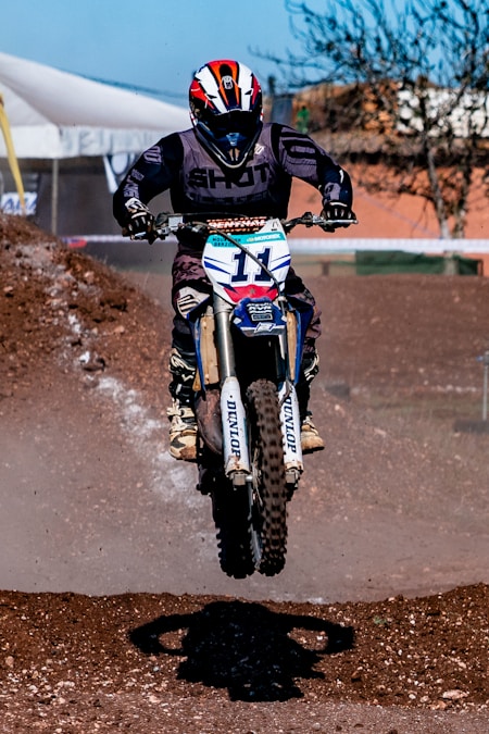 Dirt bike front knobby tire and fork close-up on a motocross track