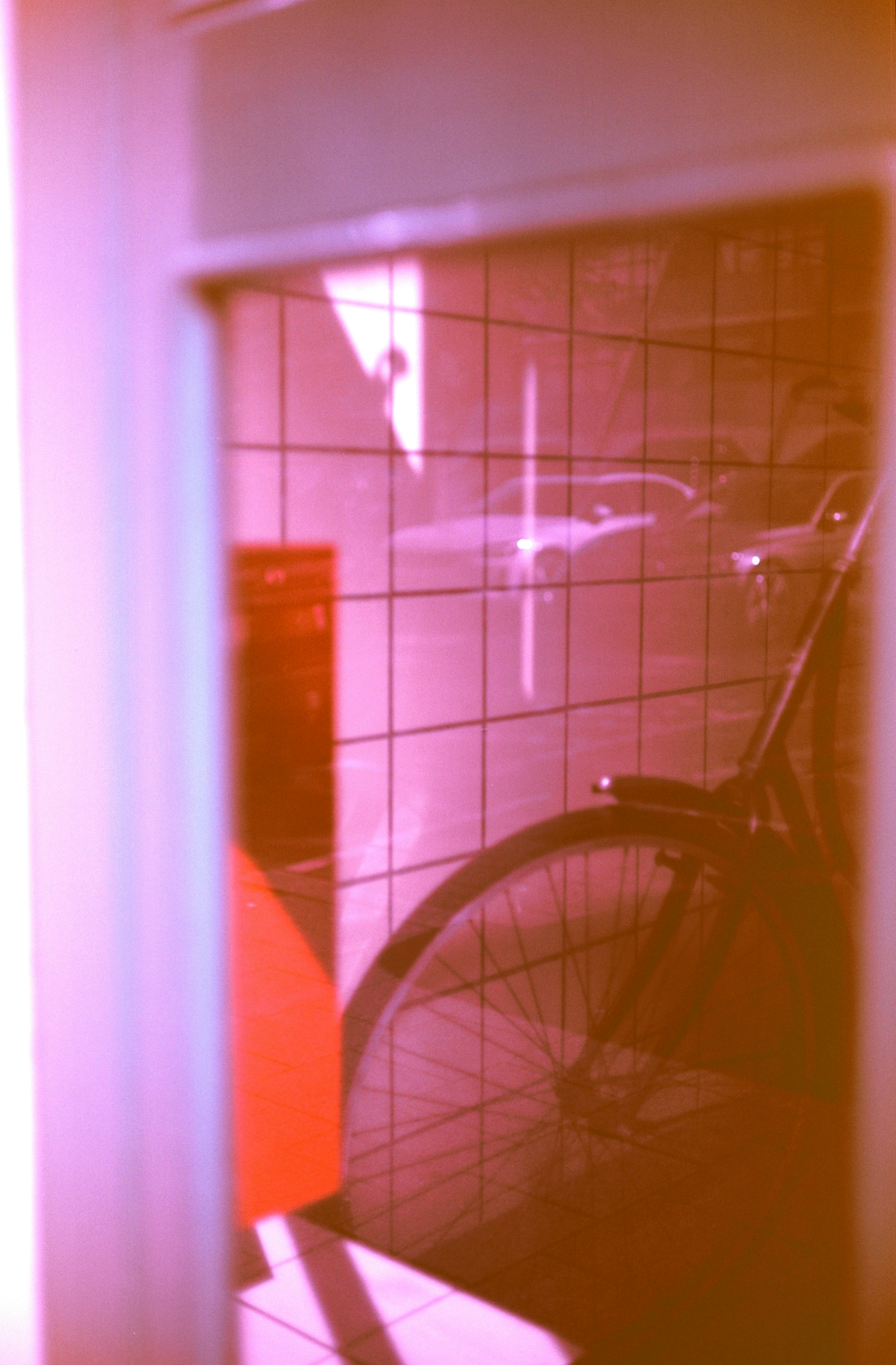Bicycle wheel reflected in a tiled wall