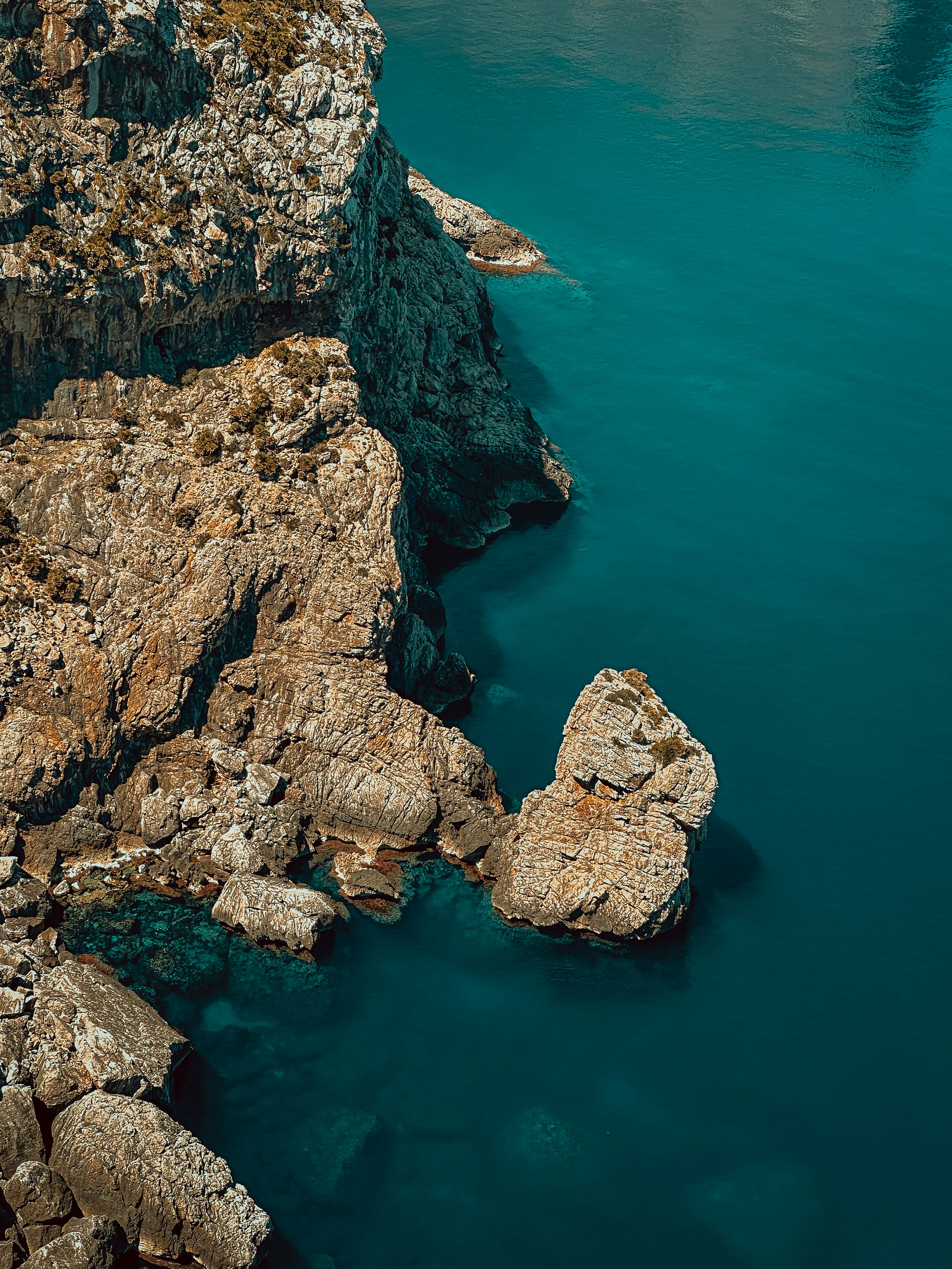 Rocky coastline meets clear blue ocean water