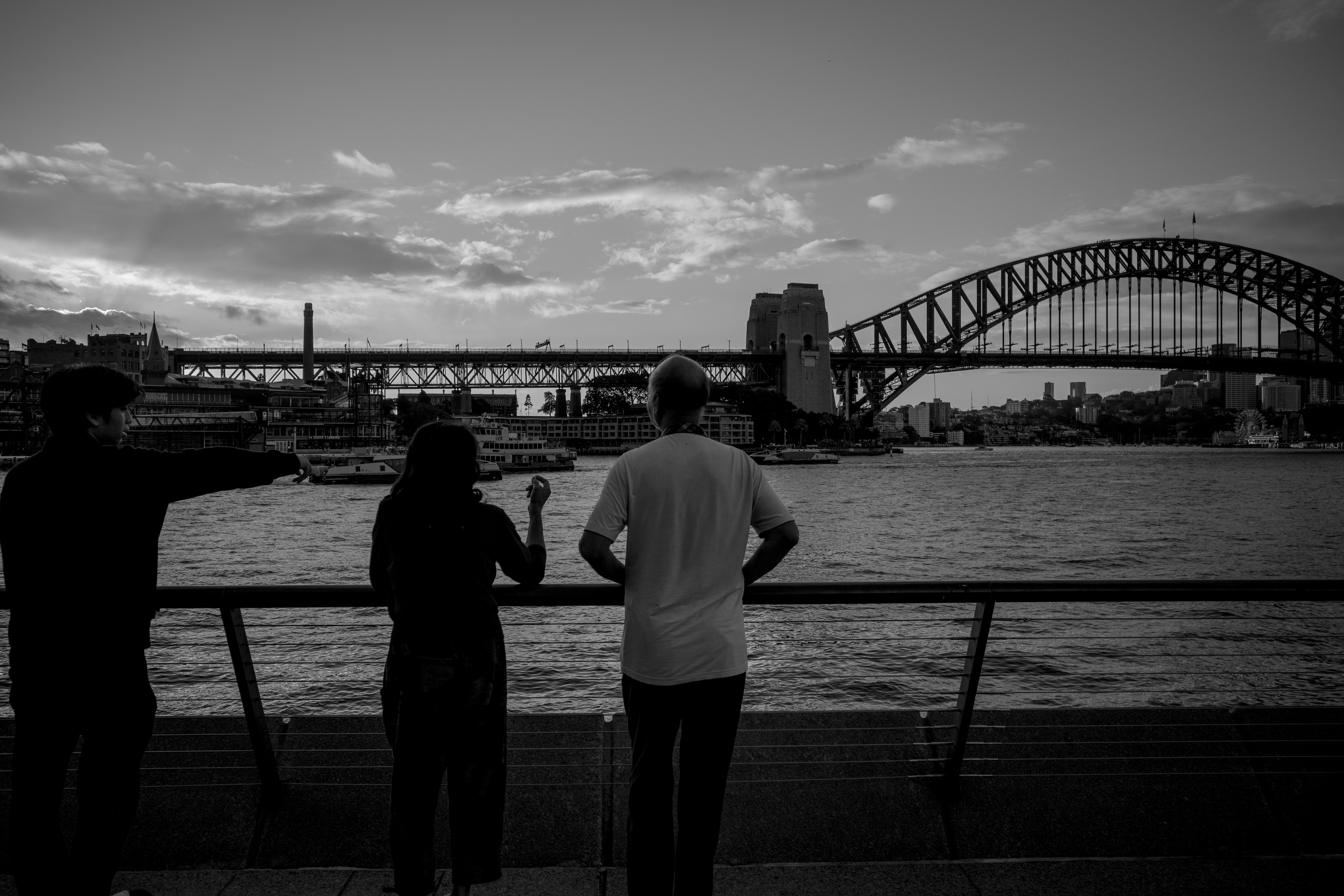 People watch sydney harbour bridge at dusk