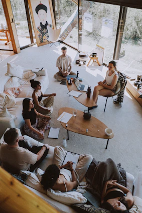 Group meditating in a bright, modern room.