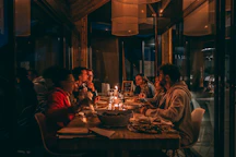 People enjoying a candlelit dinner at a dimly lit restaurant.