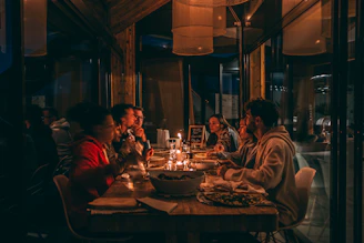 People enjoying a candlelit dinner at a dimly lit restaurant.