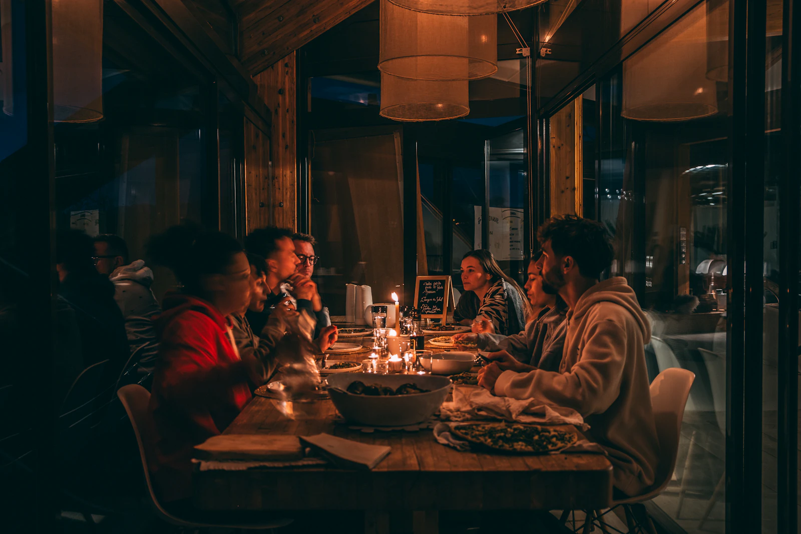 A group of diners sharing a meal at a candlelit restaurant table