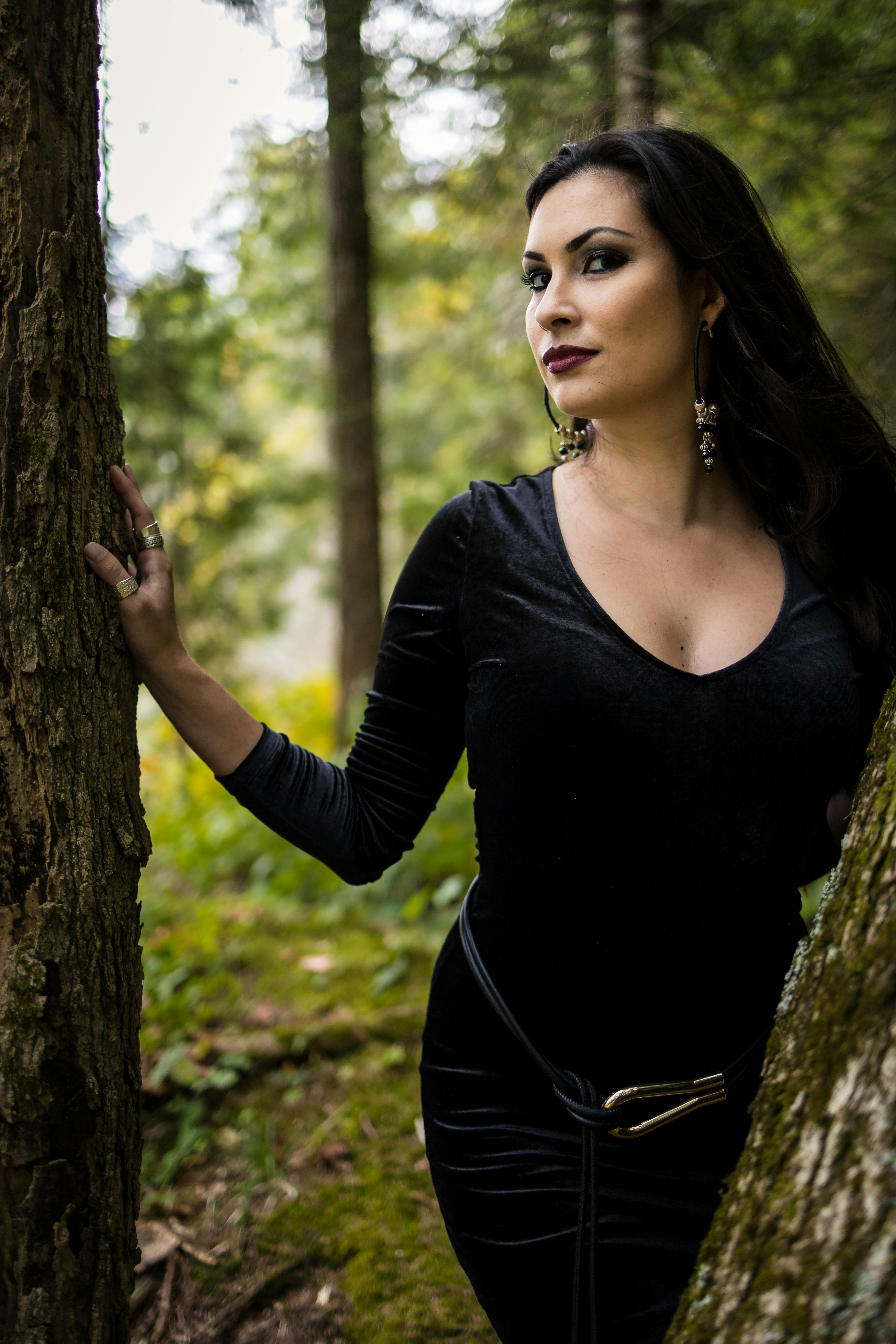 Woman in black dress posing in a forest