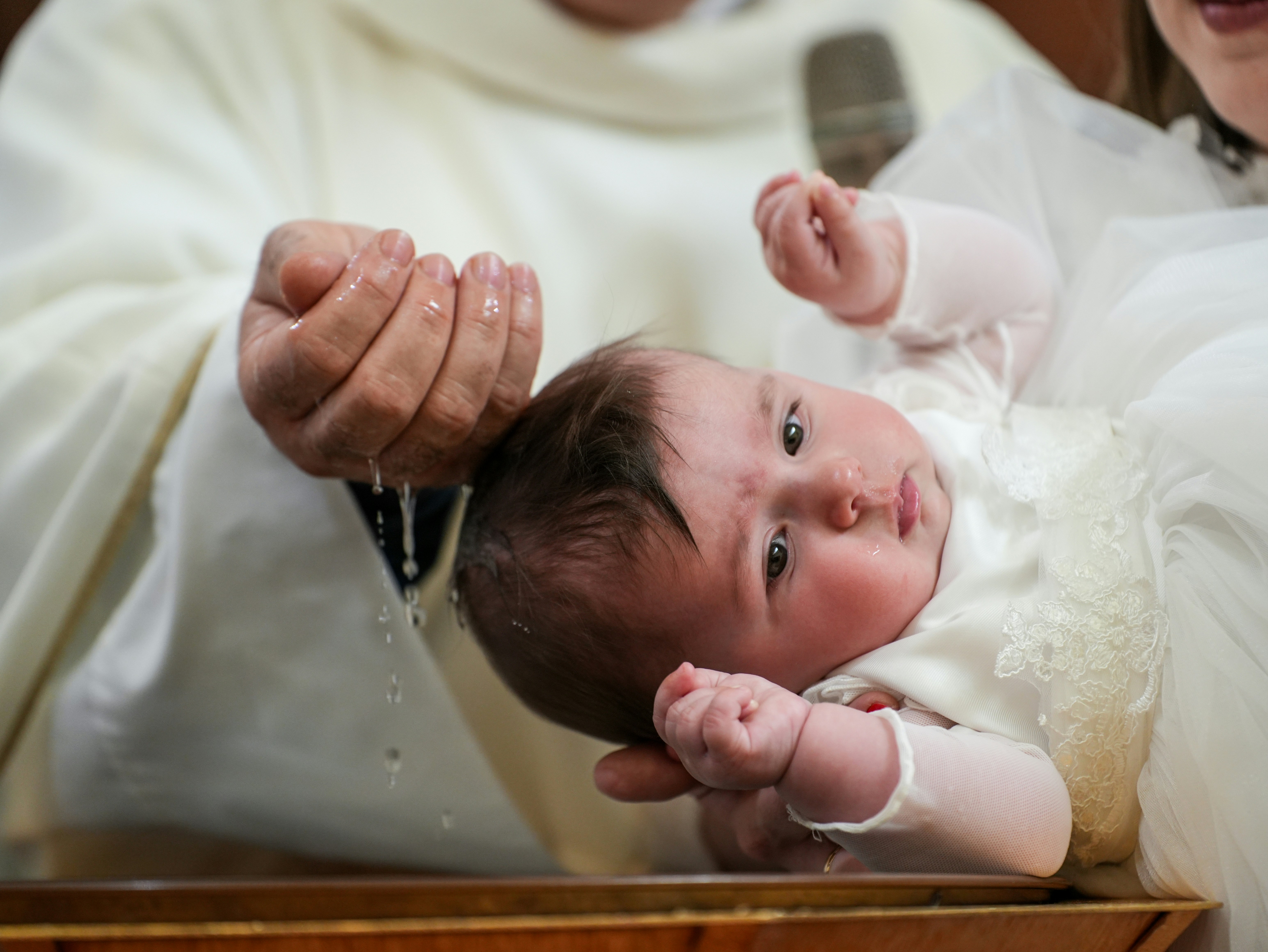 A baby being baptized in a church
