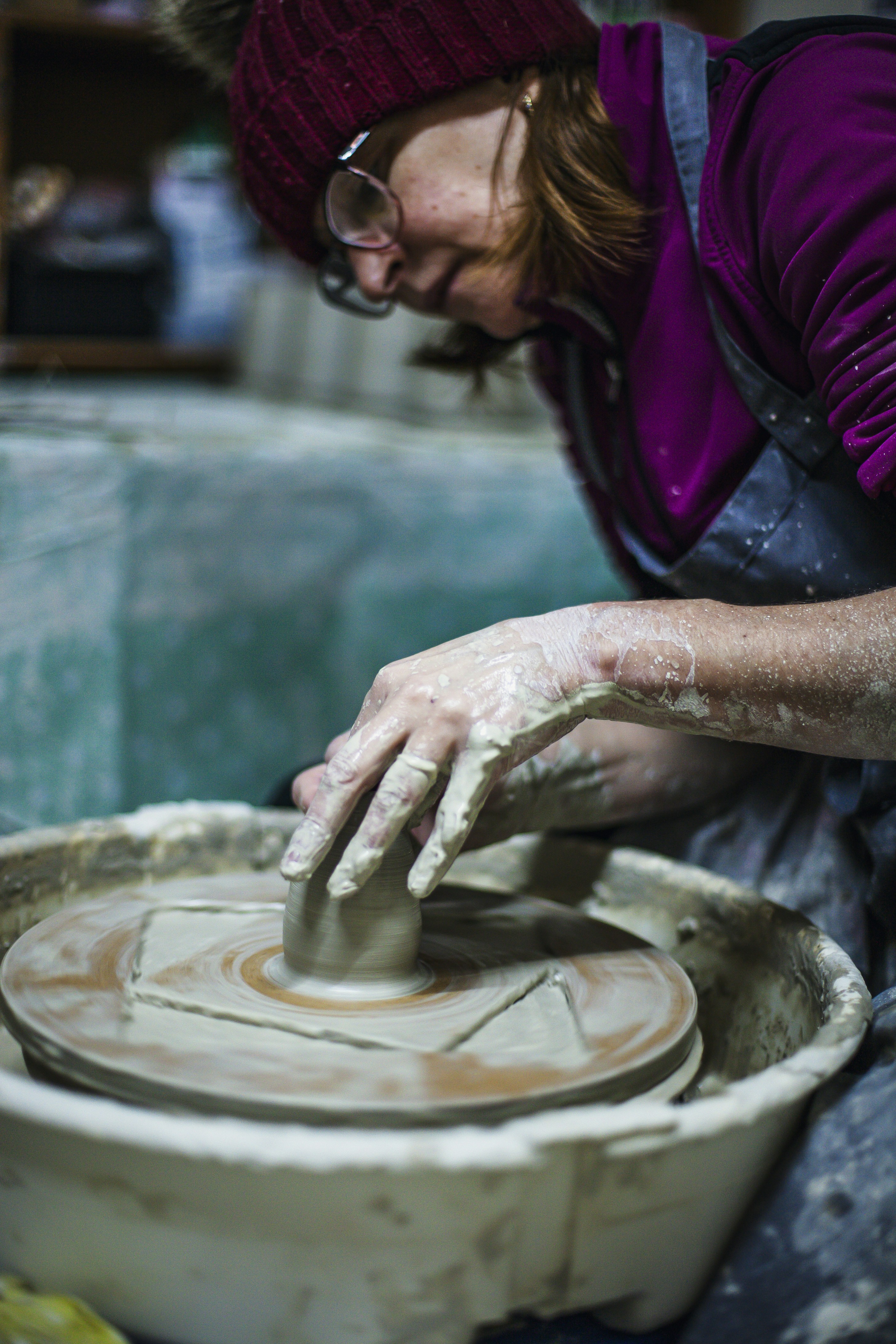 Woman shaping clay on a pottery wheel