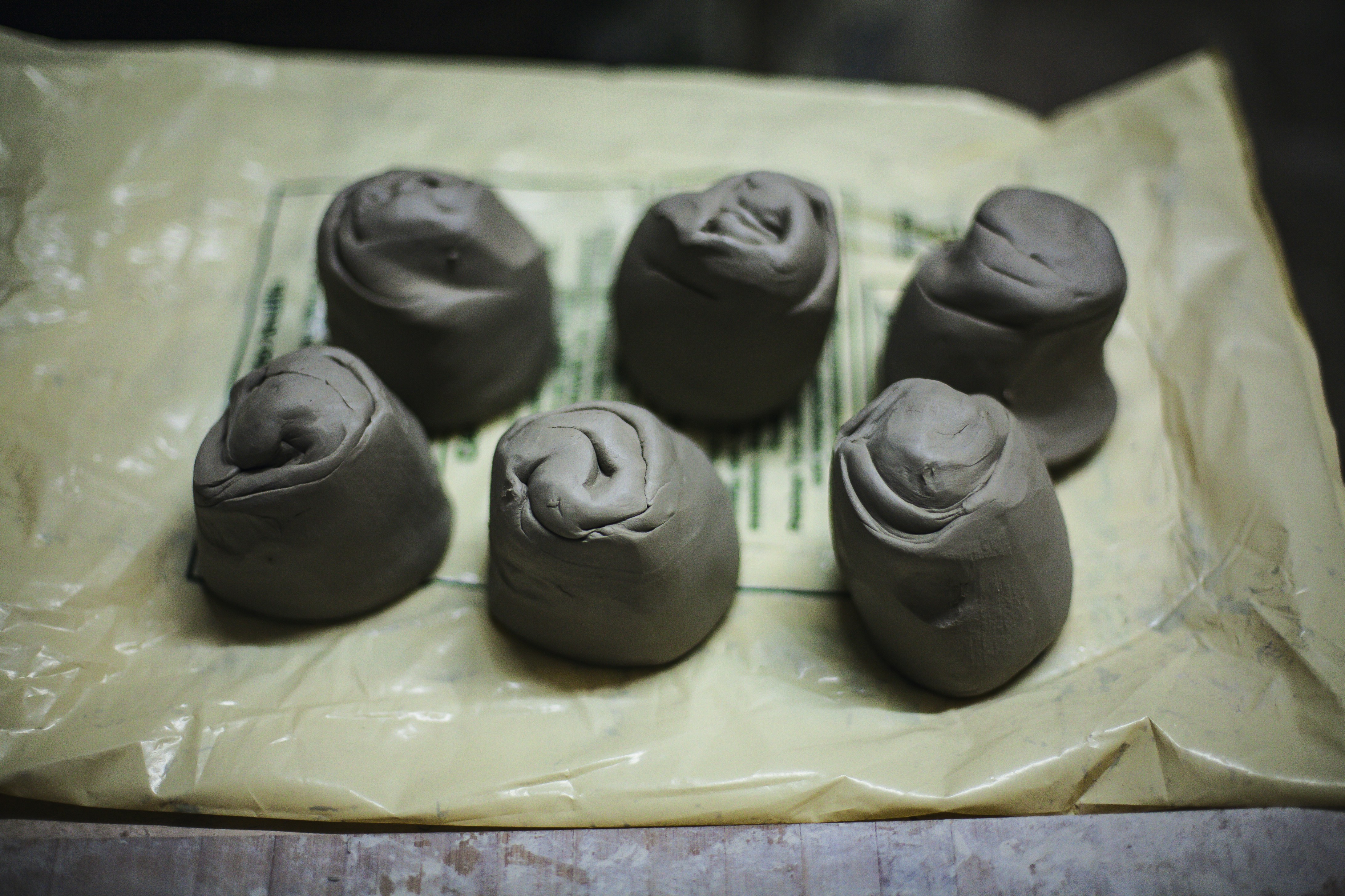 Six small clay balls on a yellow surface.