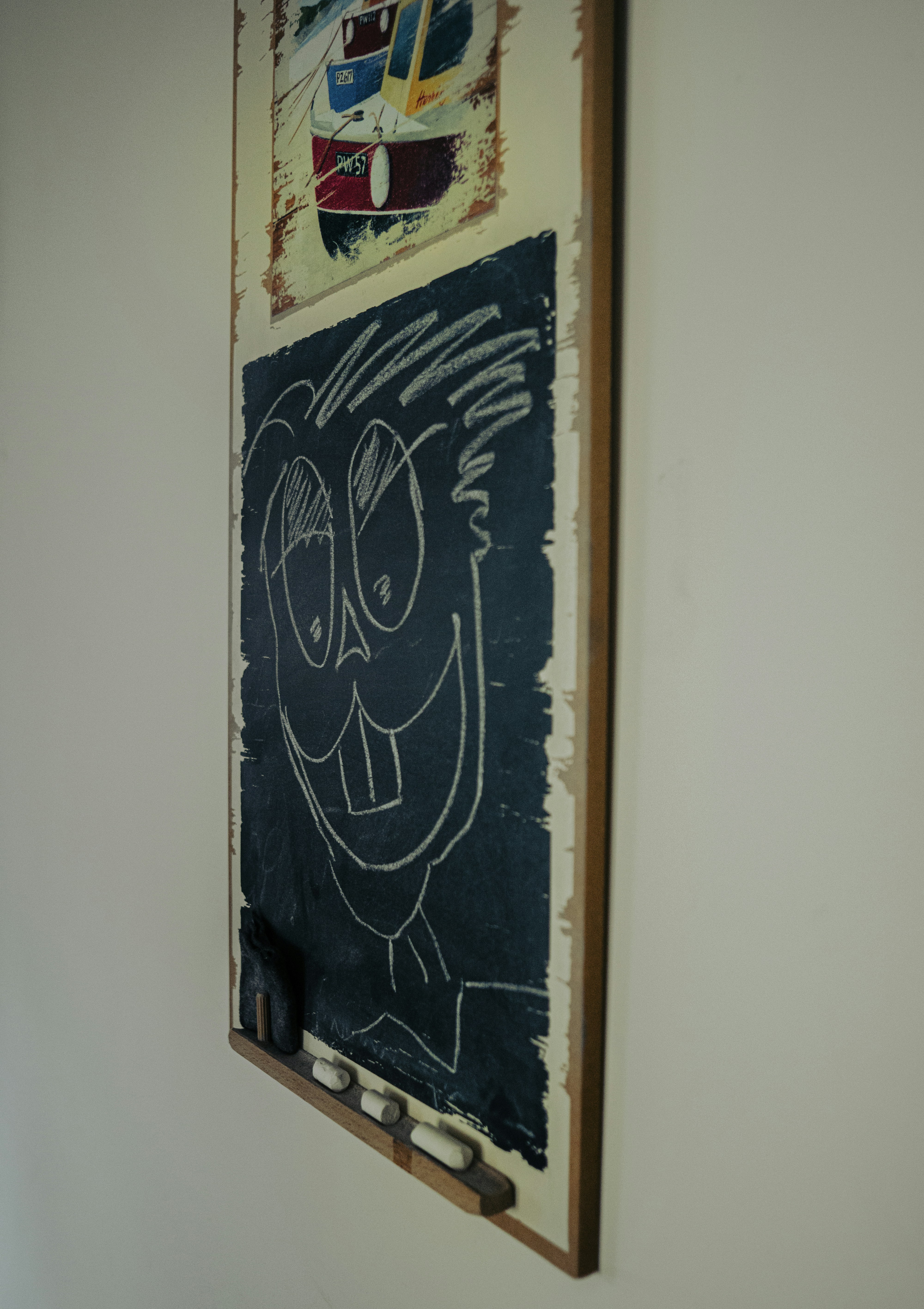 Chalk drawing of a cartoon face on a blackboard.