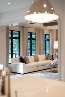 Modern living room with large sectional sofa and windows.