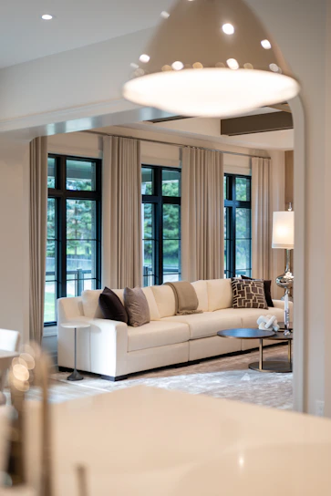 Modern living room with large sectional sofa and windows.