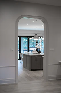 Arched doorway leading into a modern kitchen with island
