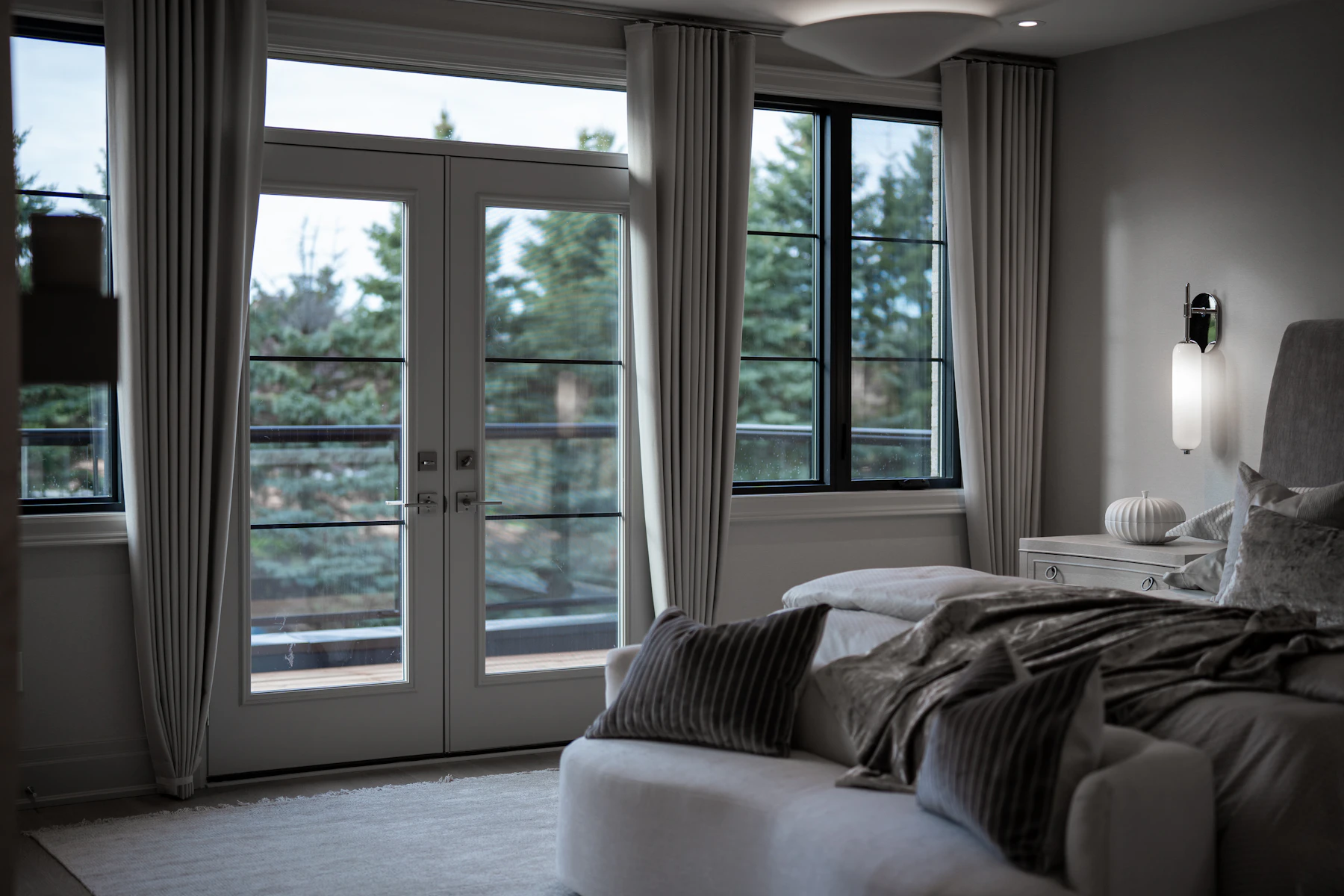 Quiet bedroom in an upscale home with large windows.