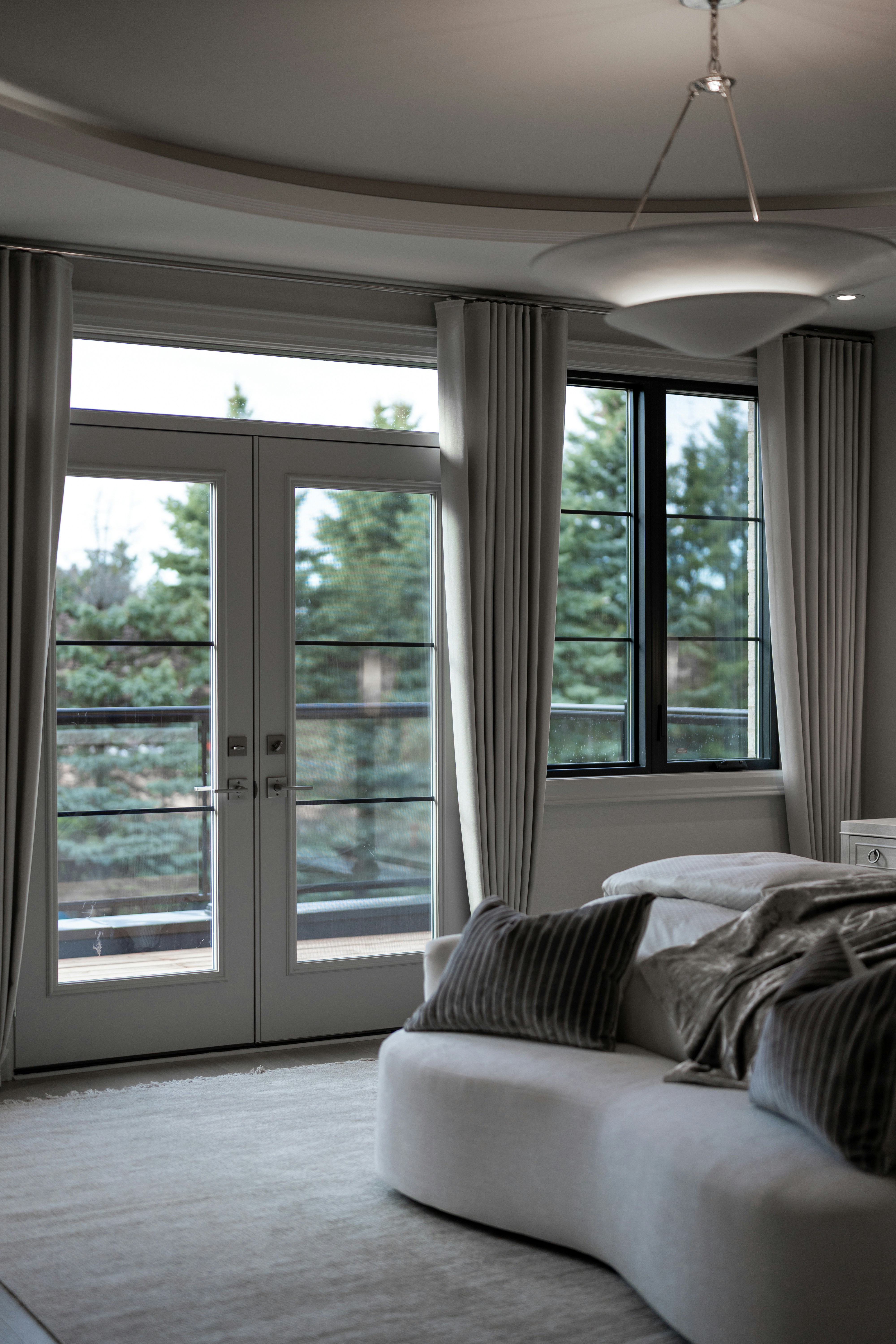 Modern bedroom featuring a motorized drapery system with blackout curtains