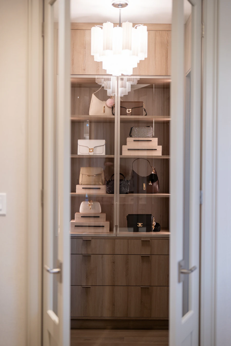 A luxurious dressing room with a chandelier seen through open doors