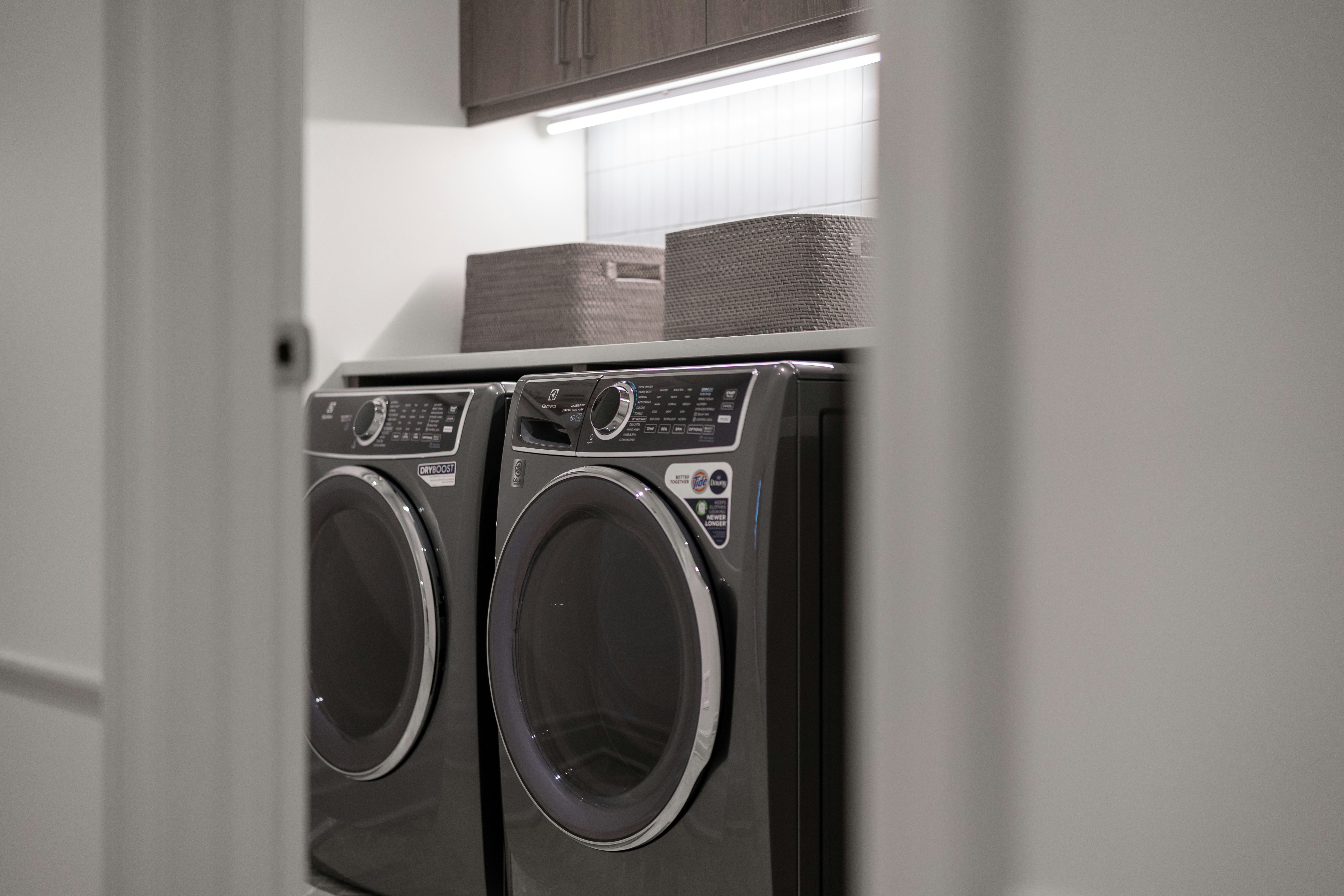 Modern laundry room with matching washer and dryer.