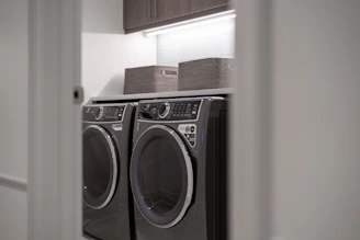 Modern laundry room with matching washer and dryer.