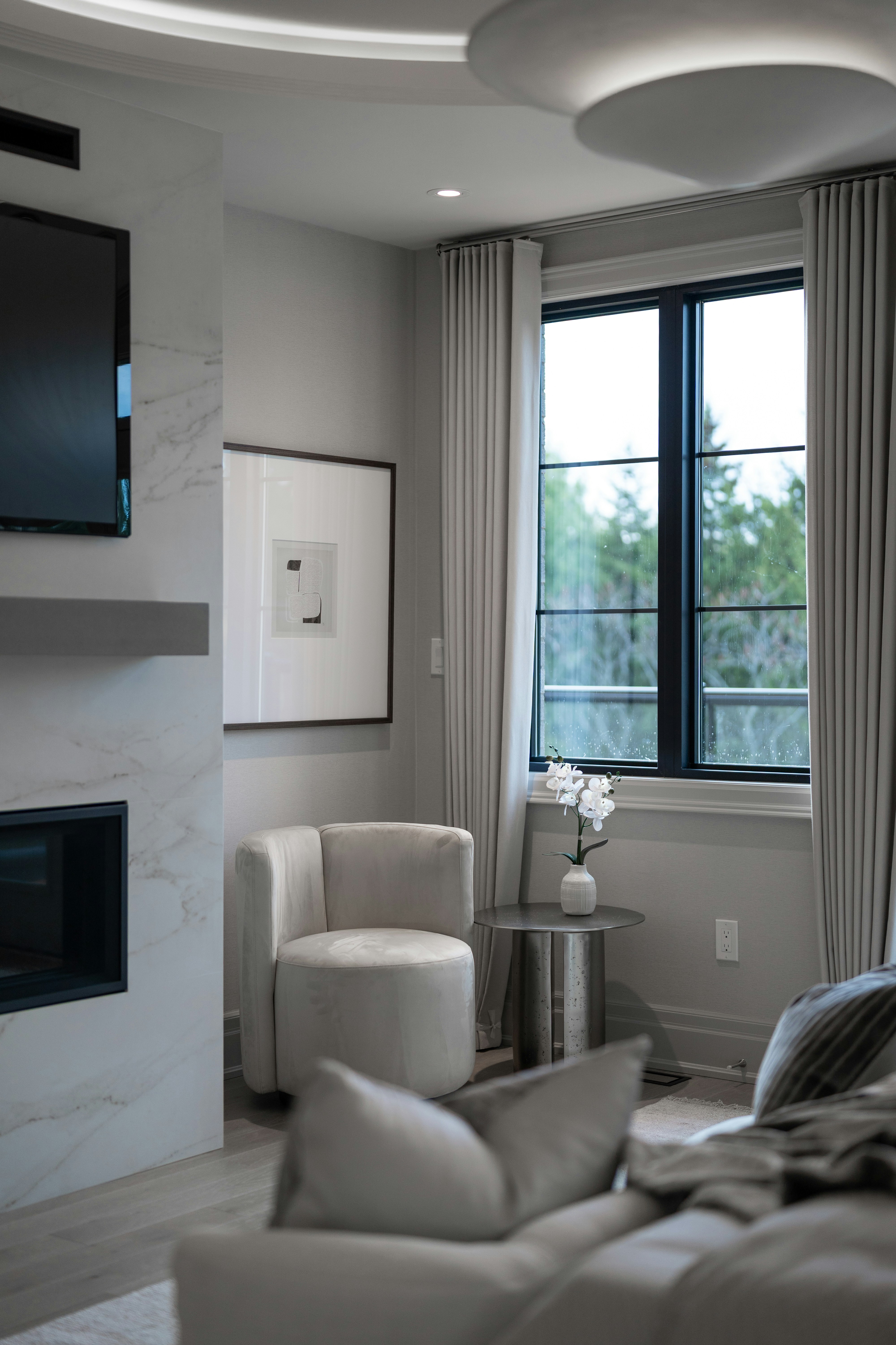 Modern bedroom with fireplace and large window.