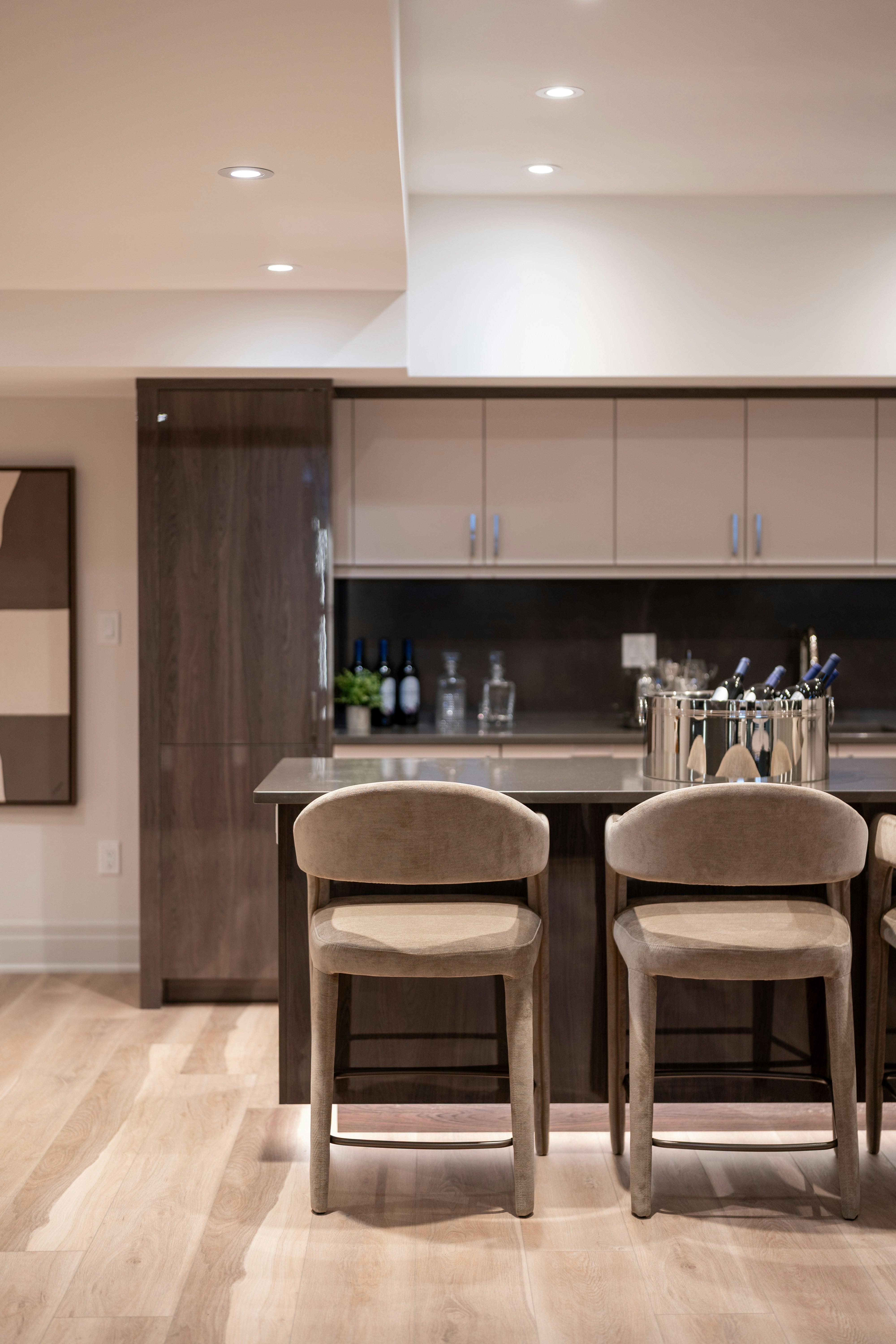 Modern kitchen island with two bar stools and wine cooler.