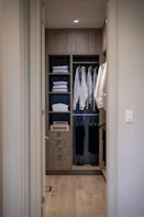 A modern walk-in closet with organized clothing and shelves