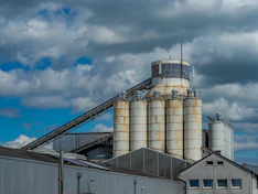 Industrial silos and buildings under a cloudy sky