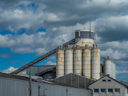 Industrial silos and buildings under a cloudy sky