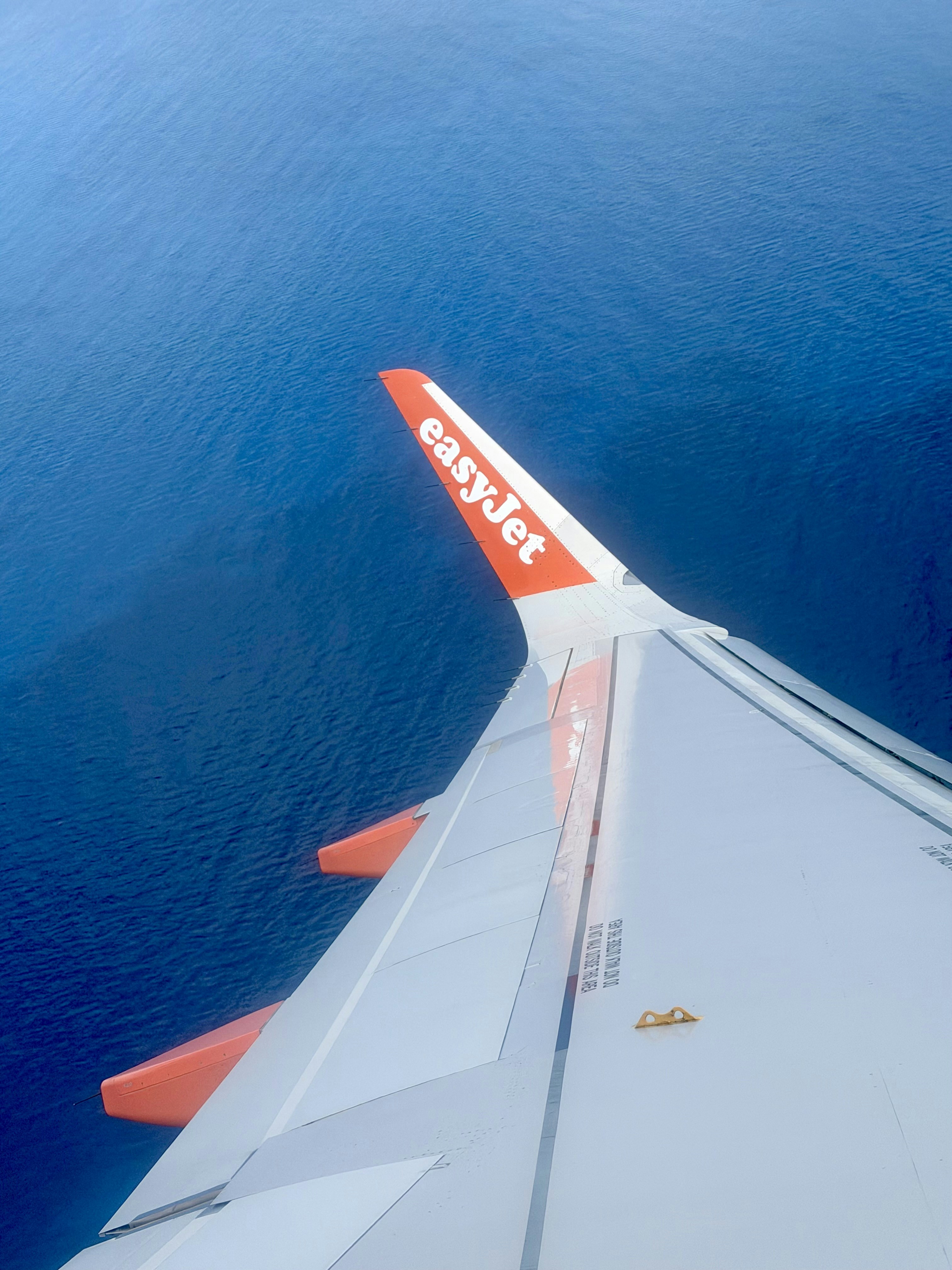 Sayap pesawat Easyjet di atas air laut biru
