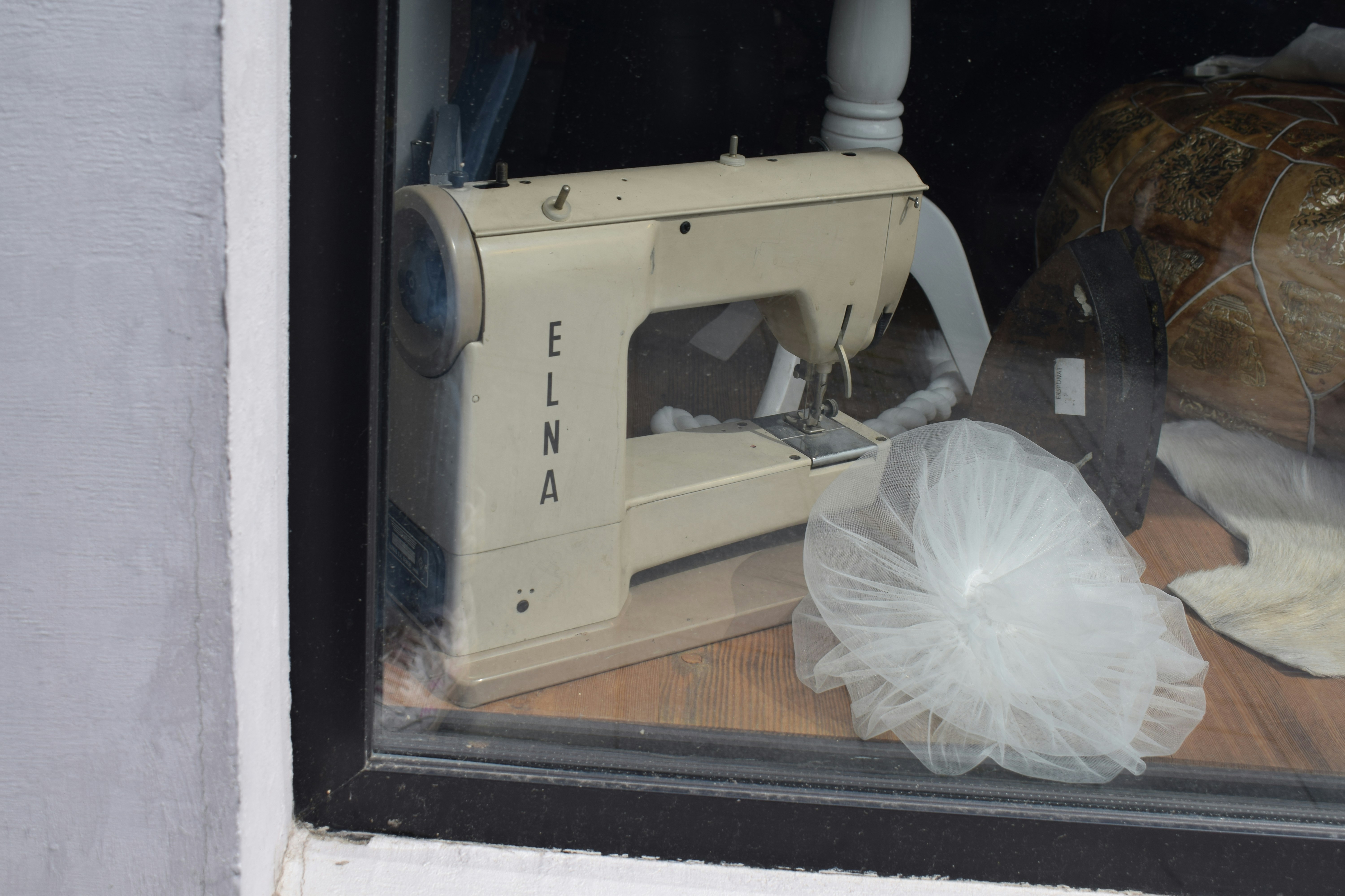 Vintage elna sewing machine displayed in a shop window.
