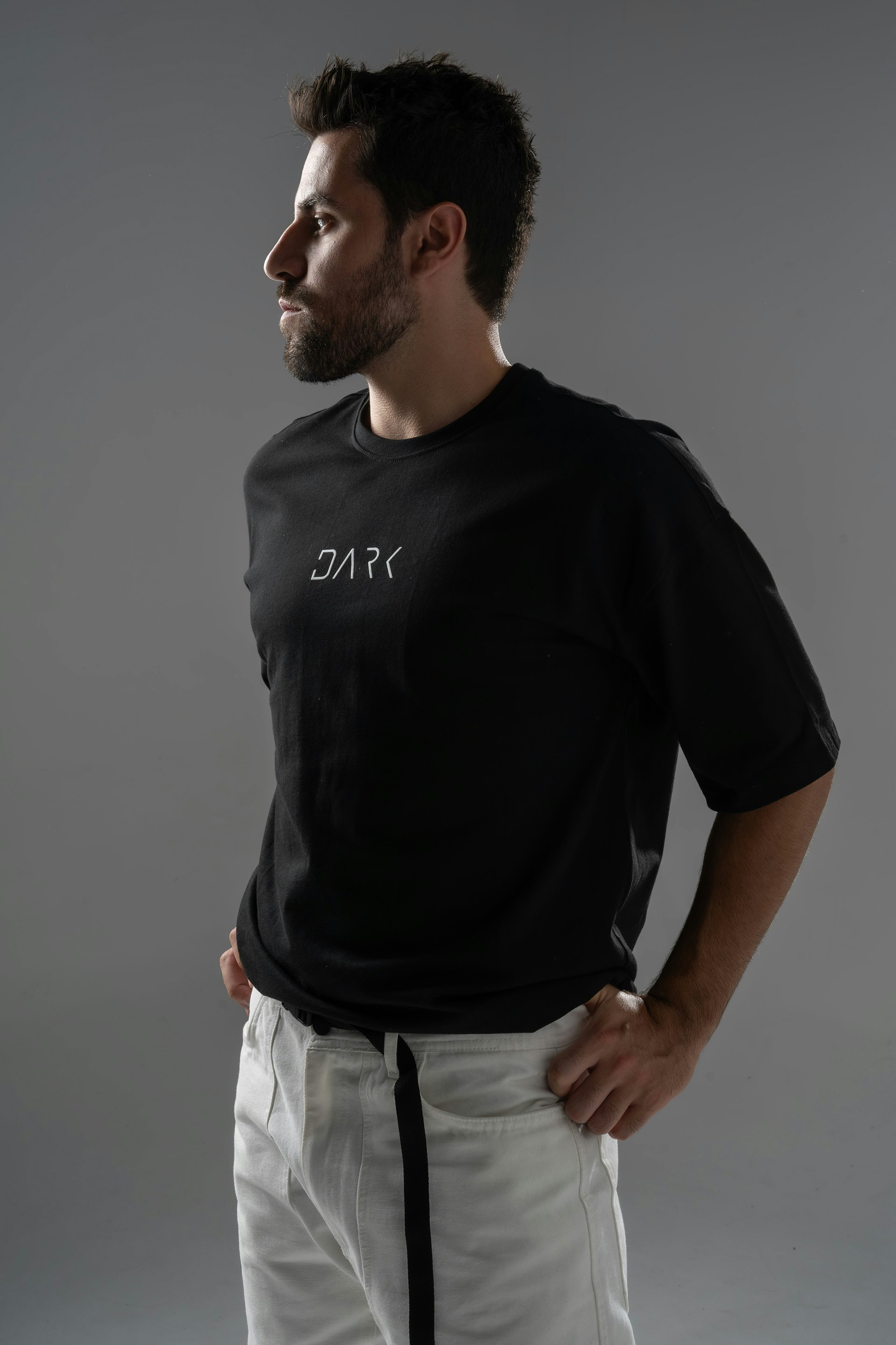 Hombre con camiseta negra y pantalones blancos