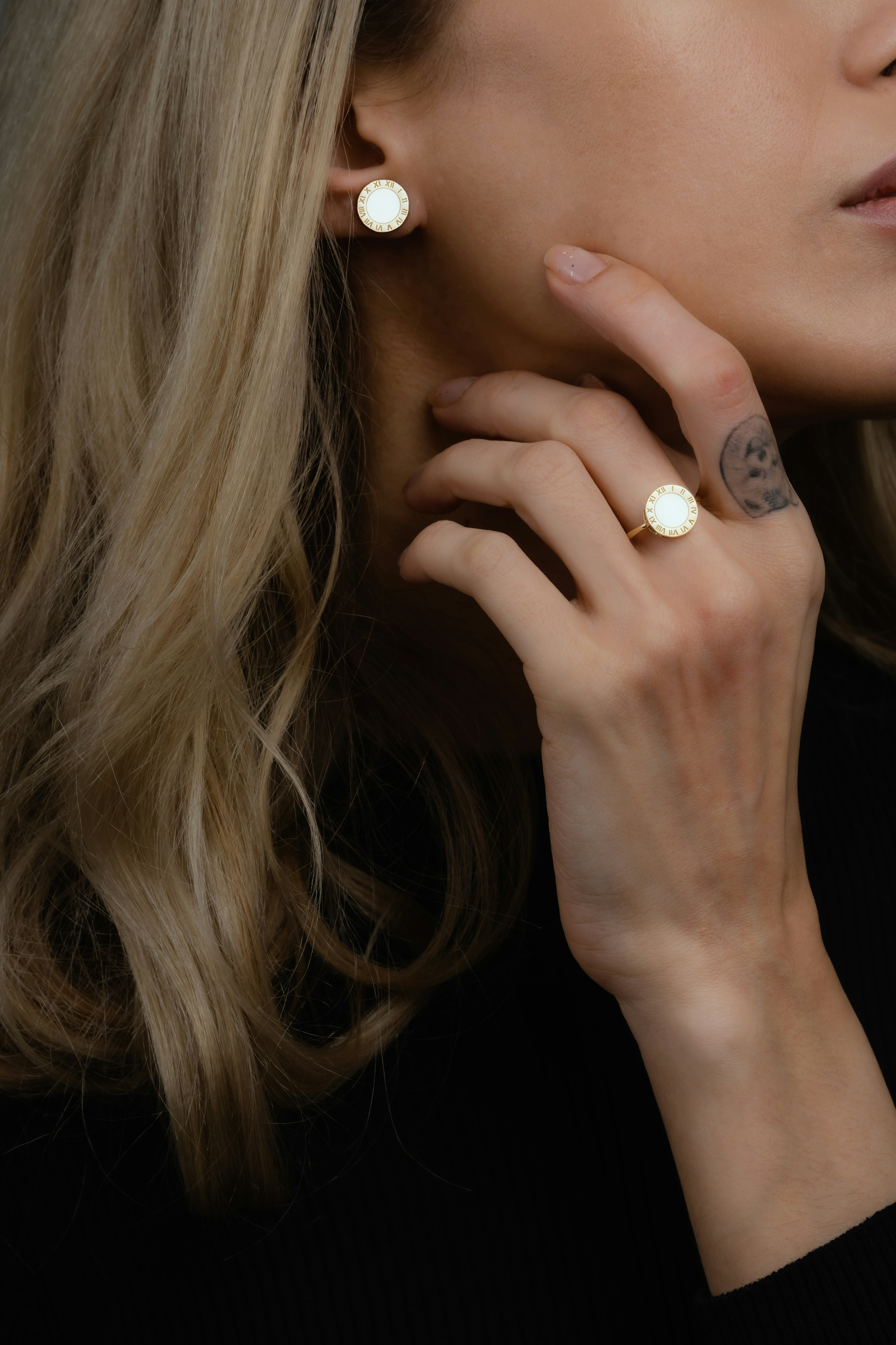 Mujer con anillo de oro y pendientes de perlas