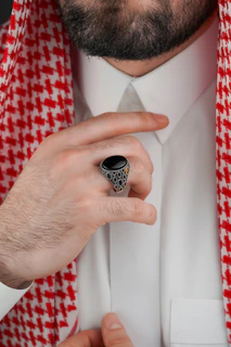 Man in traditional arab attire adjusting his collar