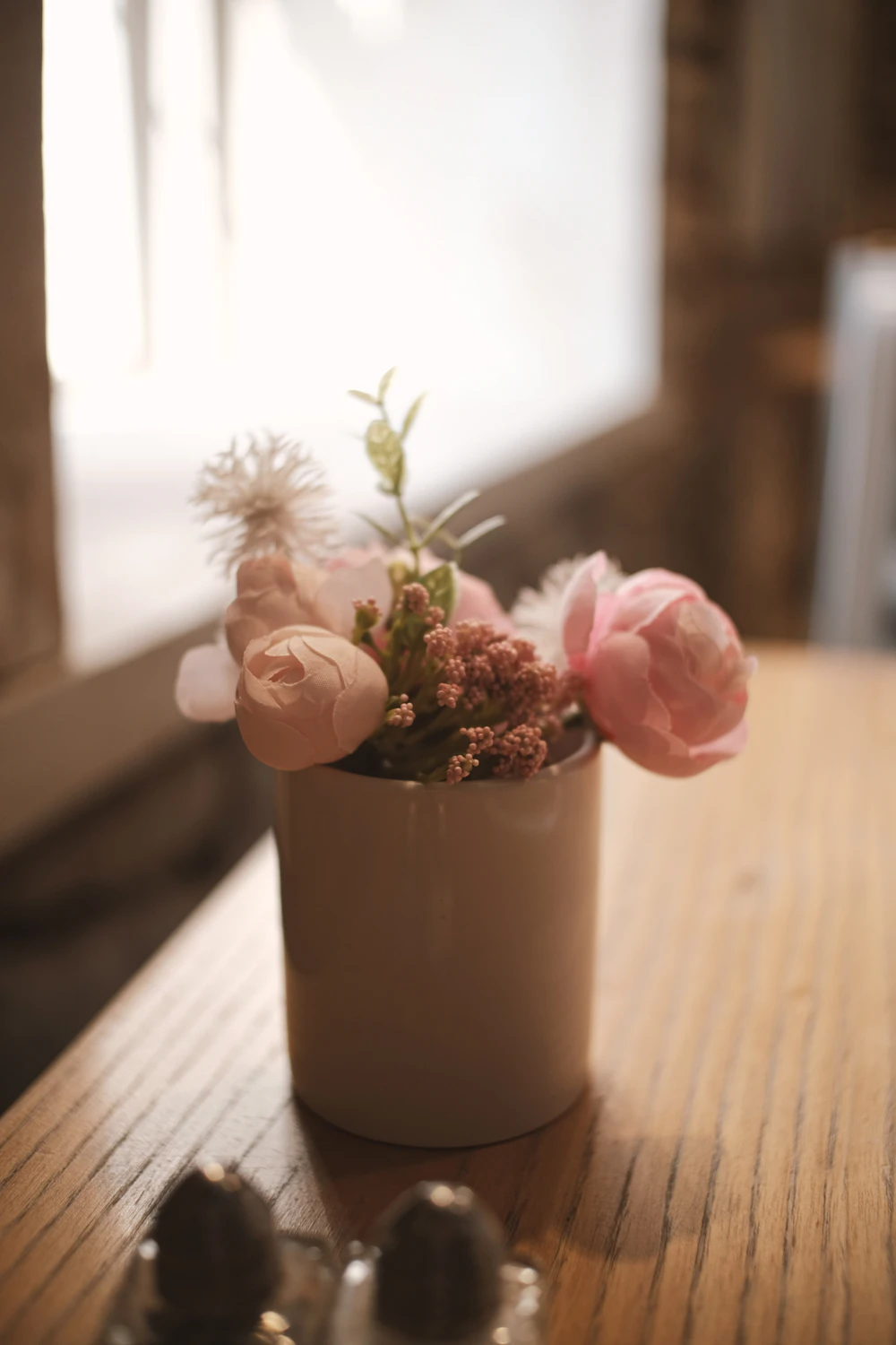 Pink flowers in a vase on a wooden table