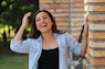 A young woman laughing with her hands in her hair