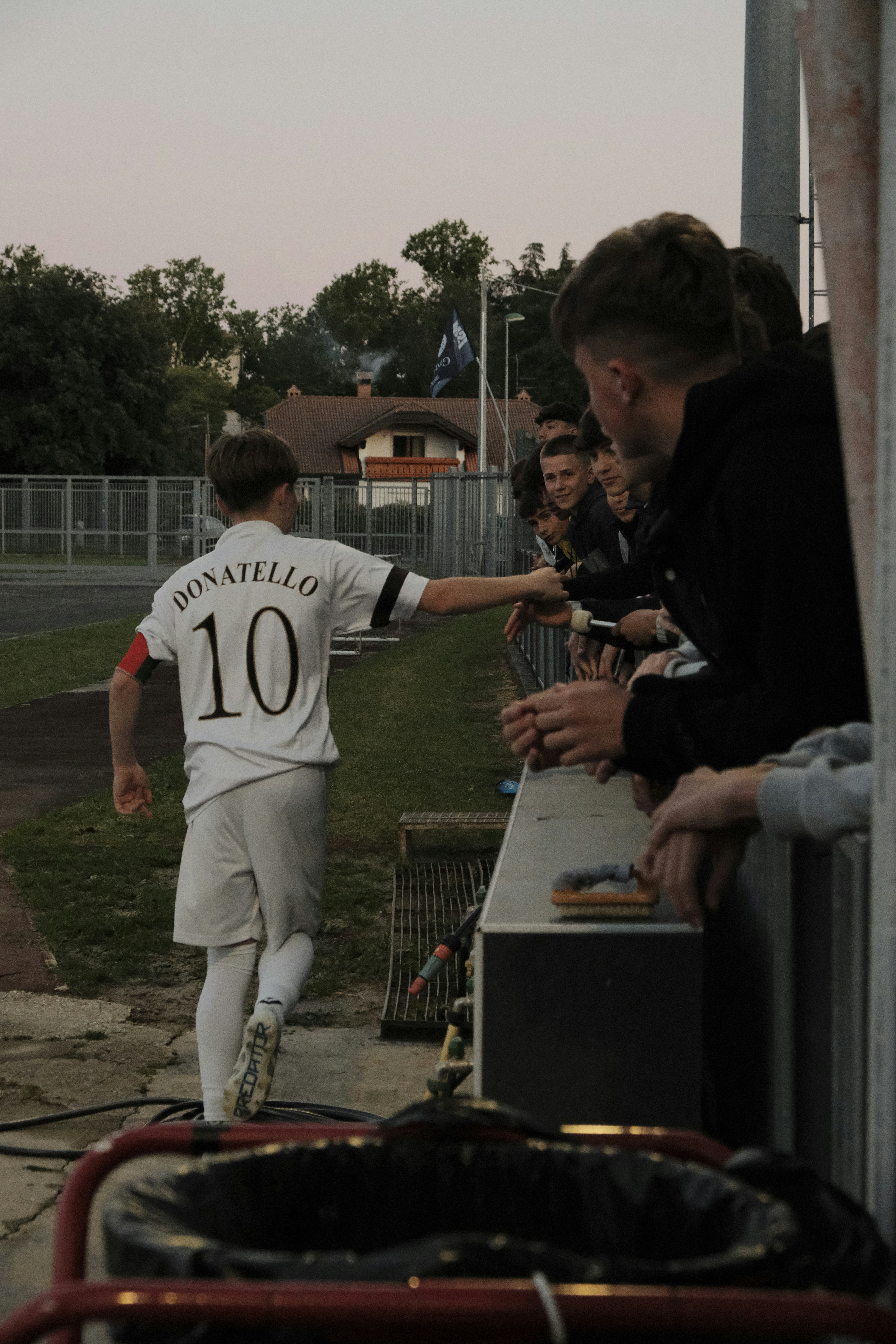 Soccer player with number 10 shakes hands with fans.