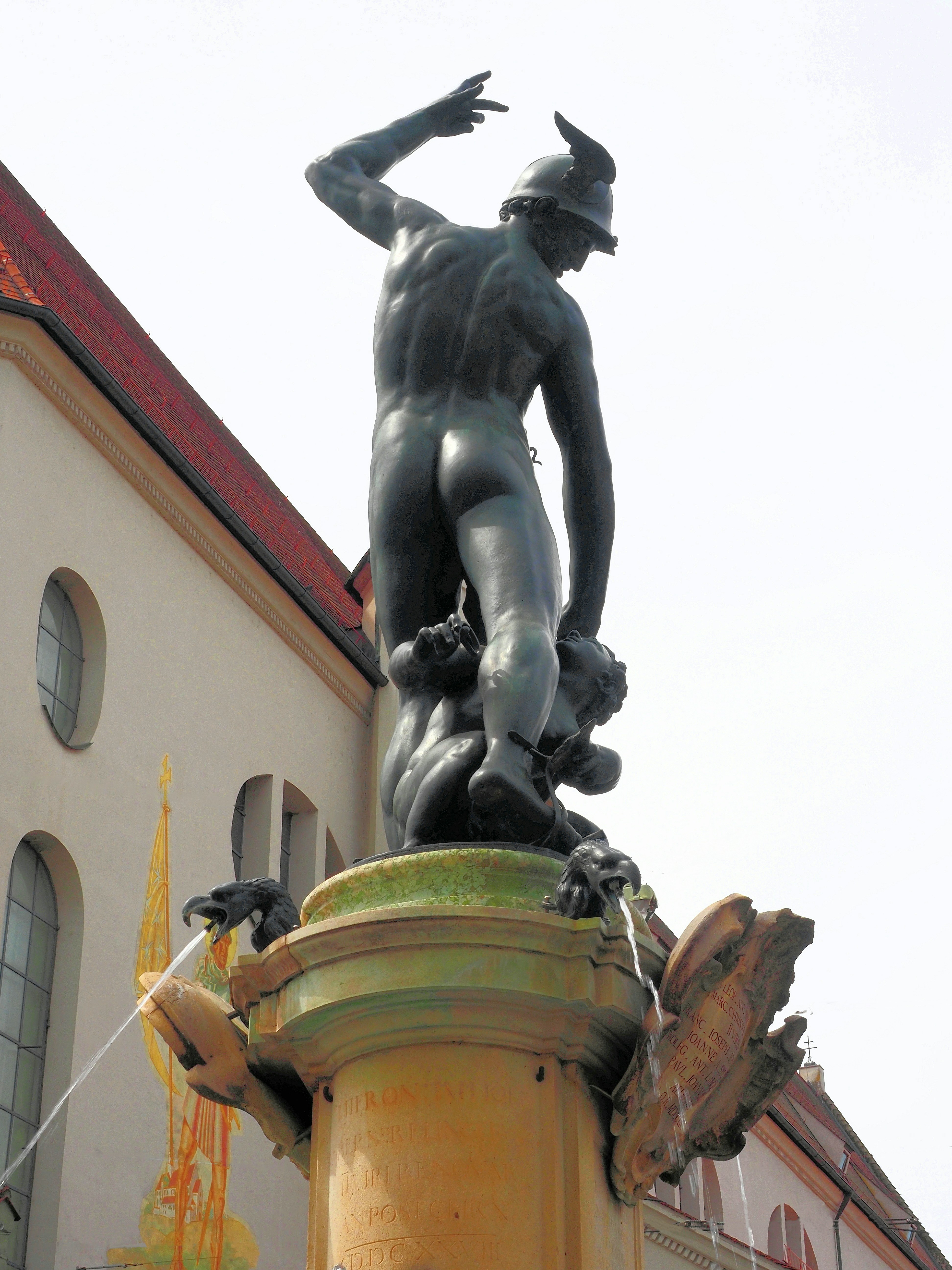 Bronze statue of a man over a creature with water