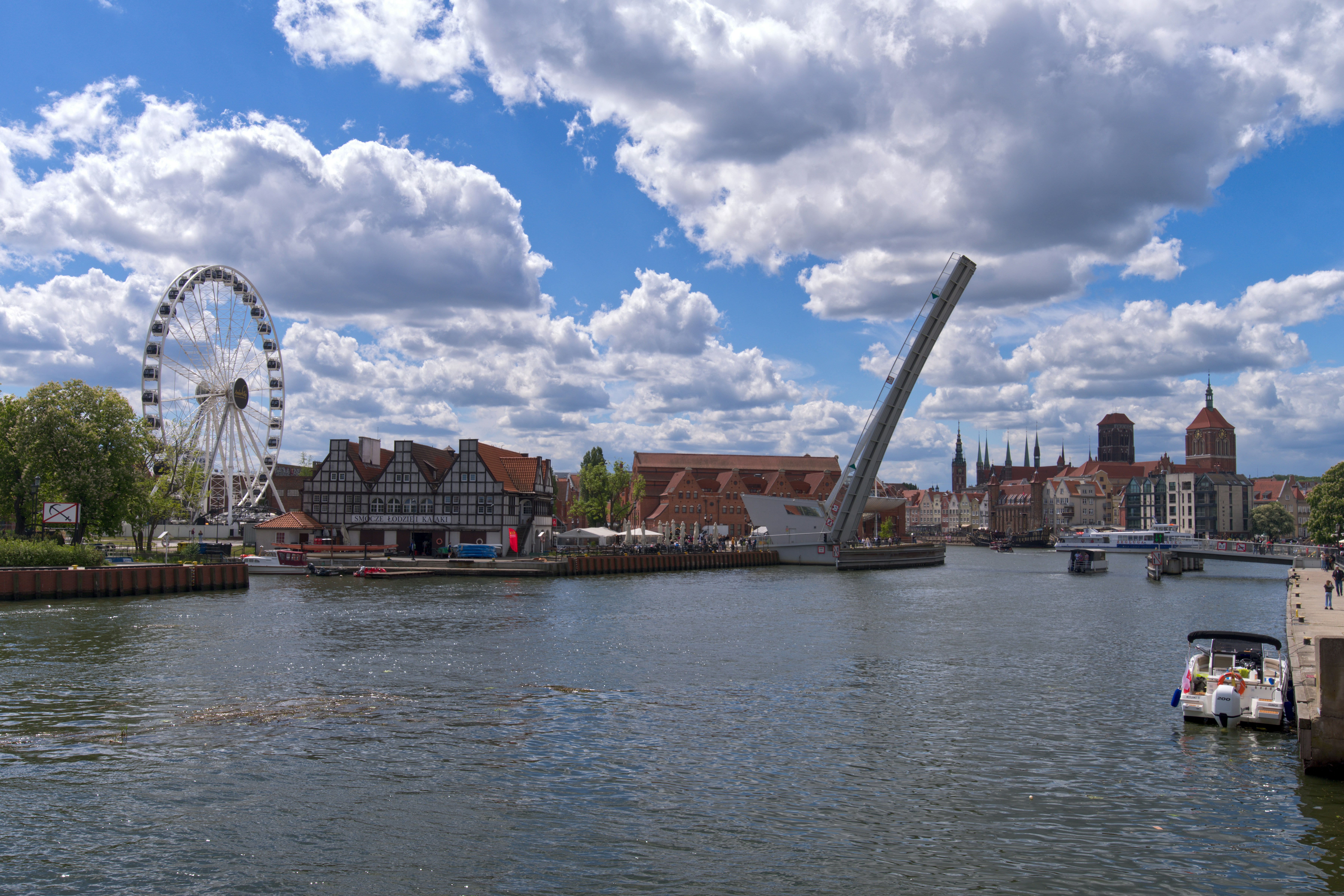 Un pont-levis au-dessus d’une rivière avec une grande roue.