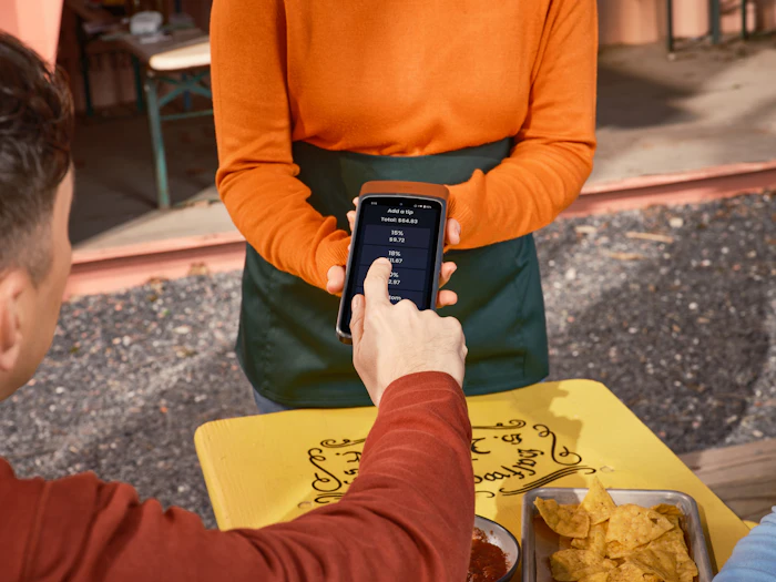 Customer paying with a smartphone at an outdoor table