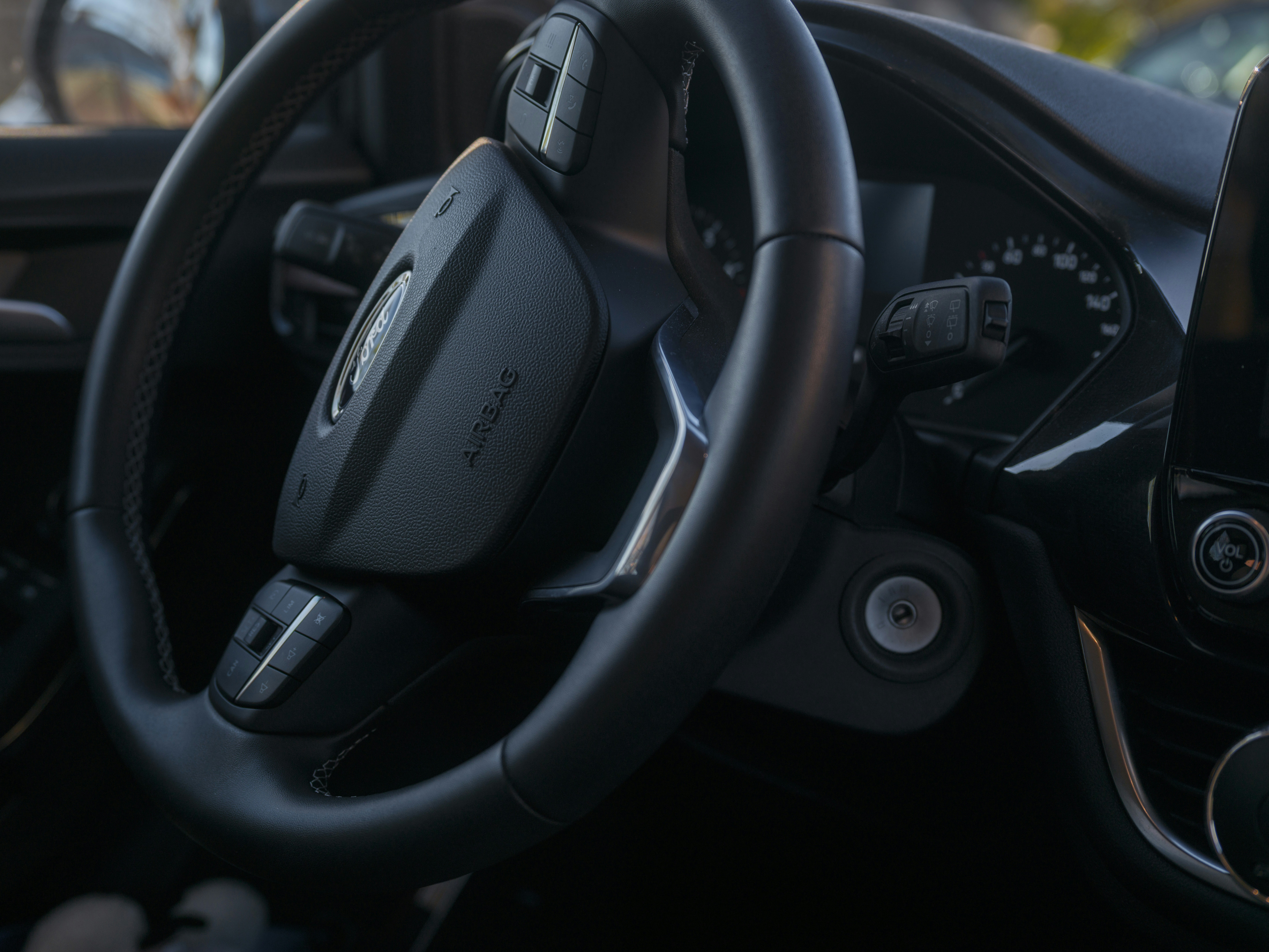 Close-up of a car's steering wheel and dashboard.