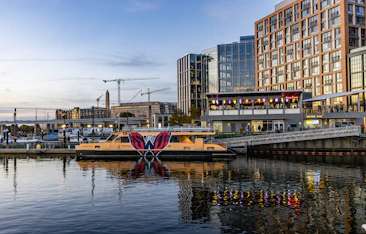 City waterfront with a boat and reflections at twilight