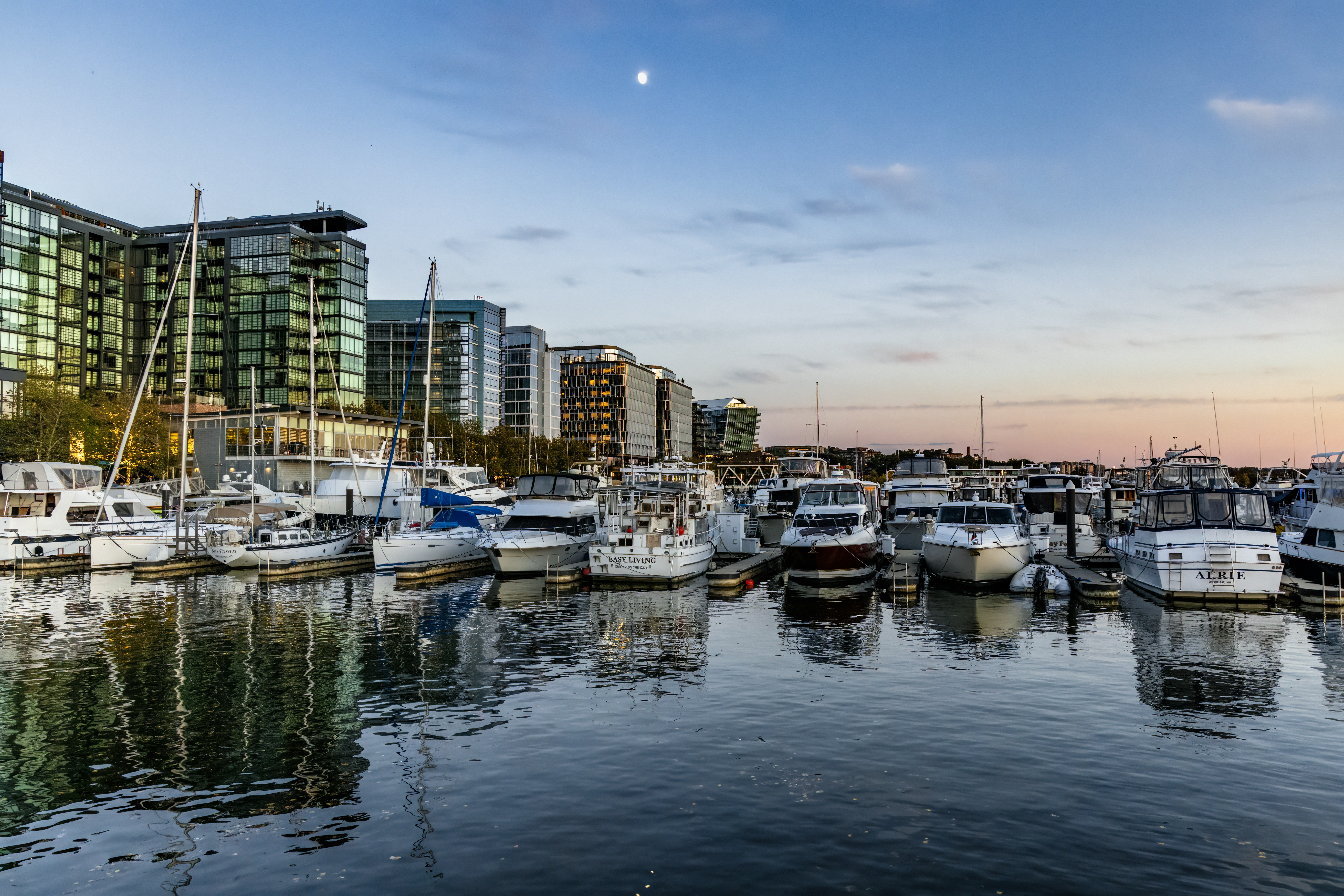 Barcos atracados en un puerto con edificios modernos detrás.
