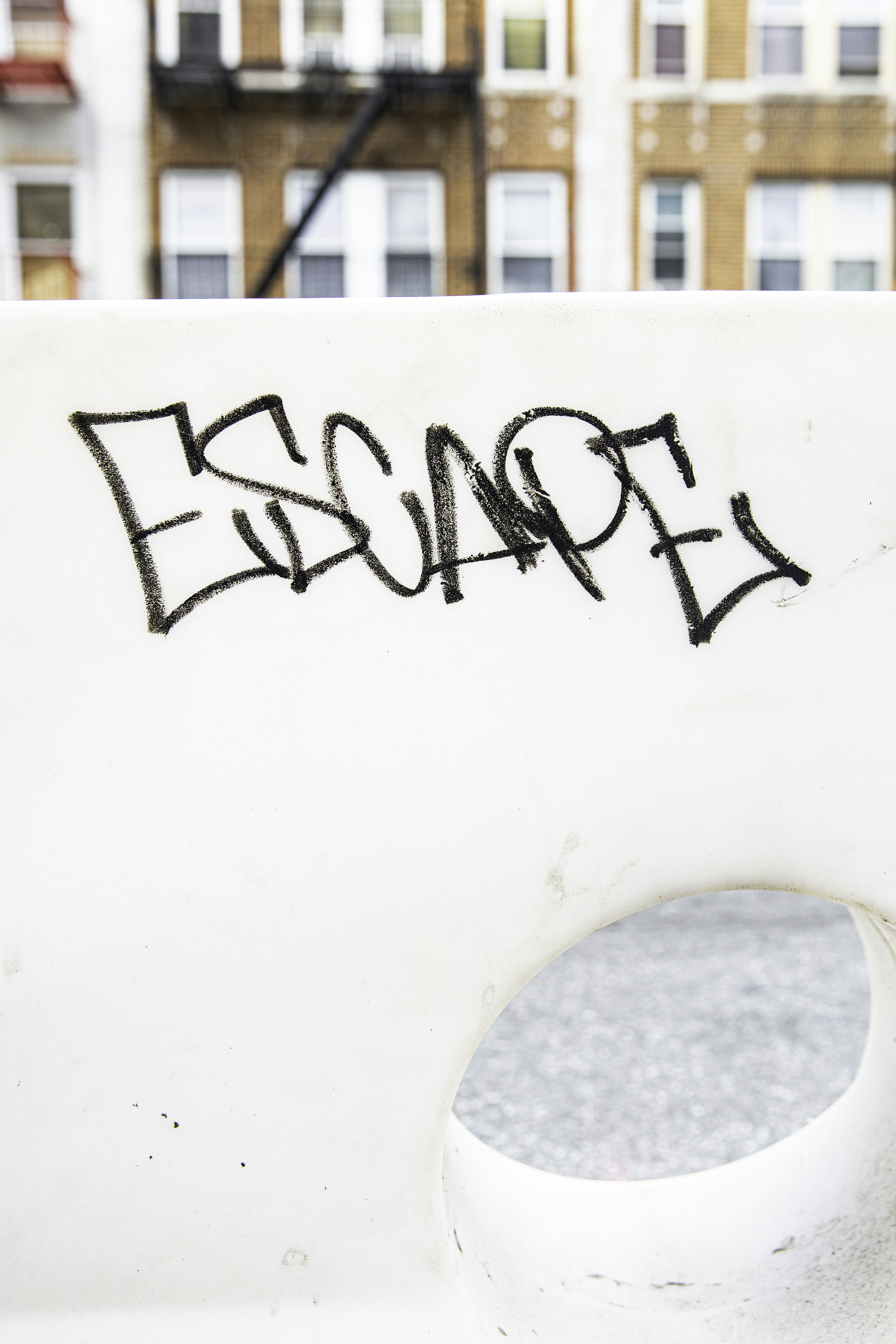 Graffiti text escape on a white wall