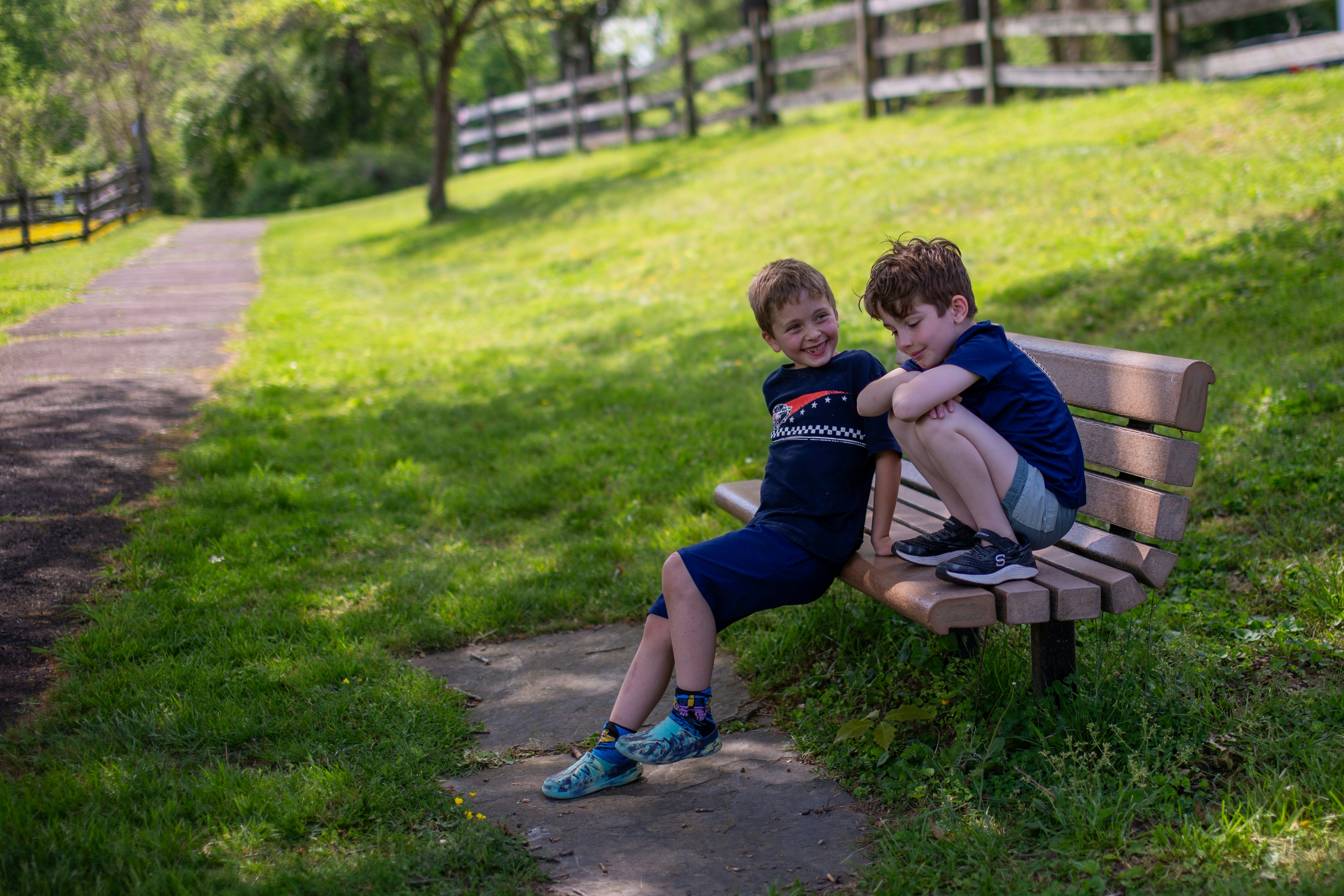 Two young boys sitting on a park bench