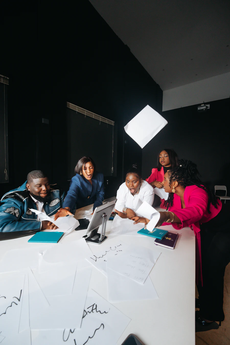 Founders celebrating a win together around a worktable covered in notes