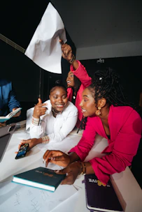 Three women celebrating and holding a white flag.